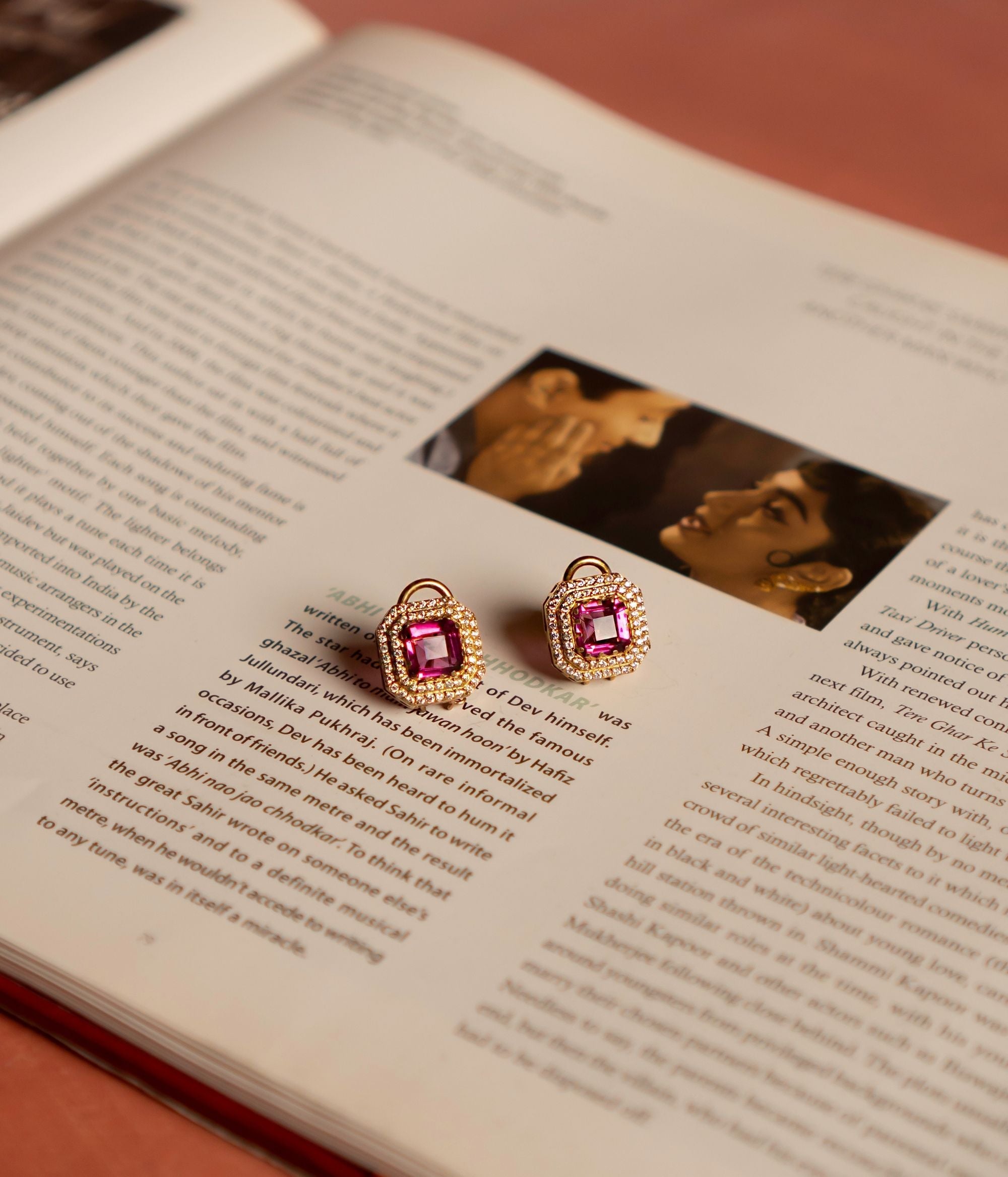 A stunning gold-plated silver stud earring in a classic square shape, featuring a vibrant pink tourmaline stone at its center. The design is elegantly framed by two layers of shimmering CZ stones, adding brilliance and sophistication. This exquisite piece exudes timeless elegance, making it a perfect accessory for any occasion.