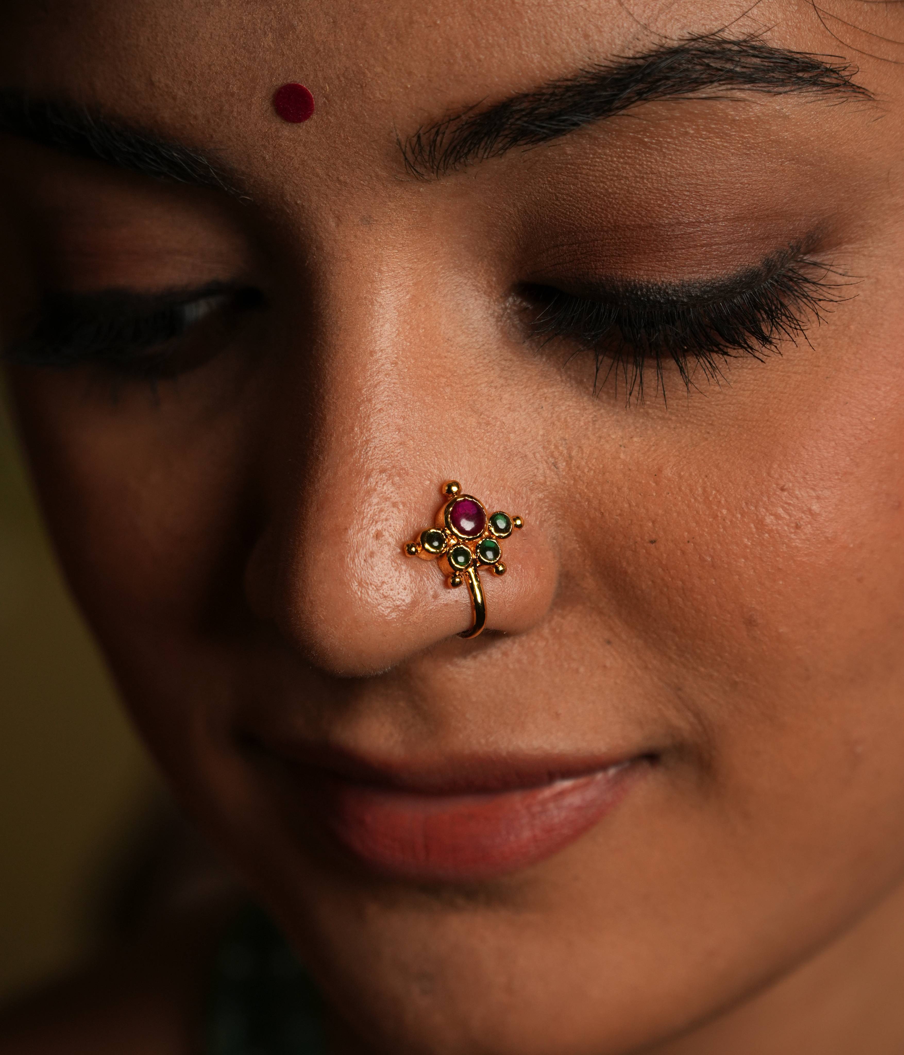 92.5 silver with gold plating Southern blossom, a vintage charm... This minimal floral nose stud shines with delicate
elegance, featuring pink and green Kundan setting. Inspired by vintage Chettinad designs, it evokes the warmth of traditional Indian craftsmanship. A tiny, timeless treasure that adds a touch of subtle sophistication.