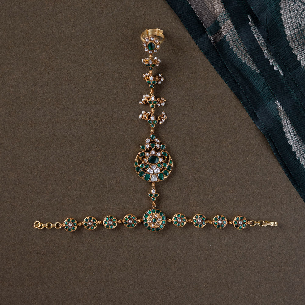 Handmade 92.5 sterling silver and 22ct gold-plated Eshna Emerald Haathphool with white and green Kundan stones, intricate floral motifs, and delicate pearls, exuding royal elegance.