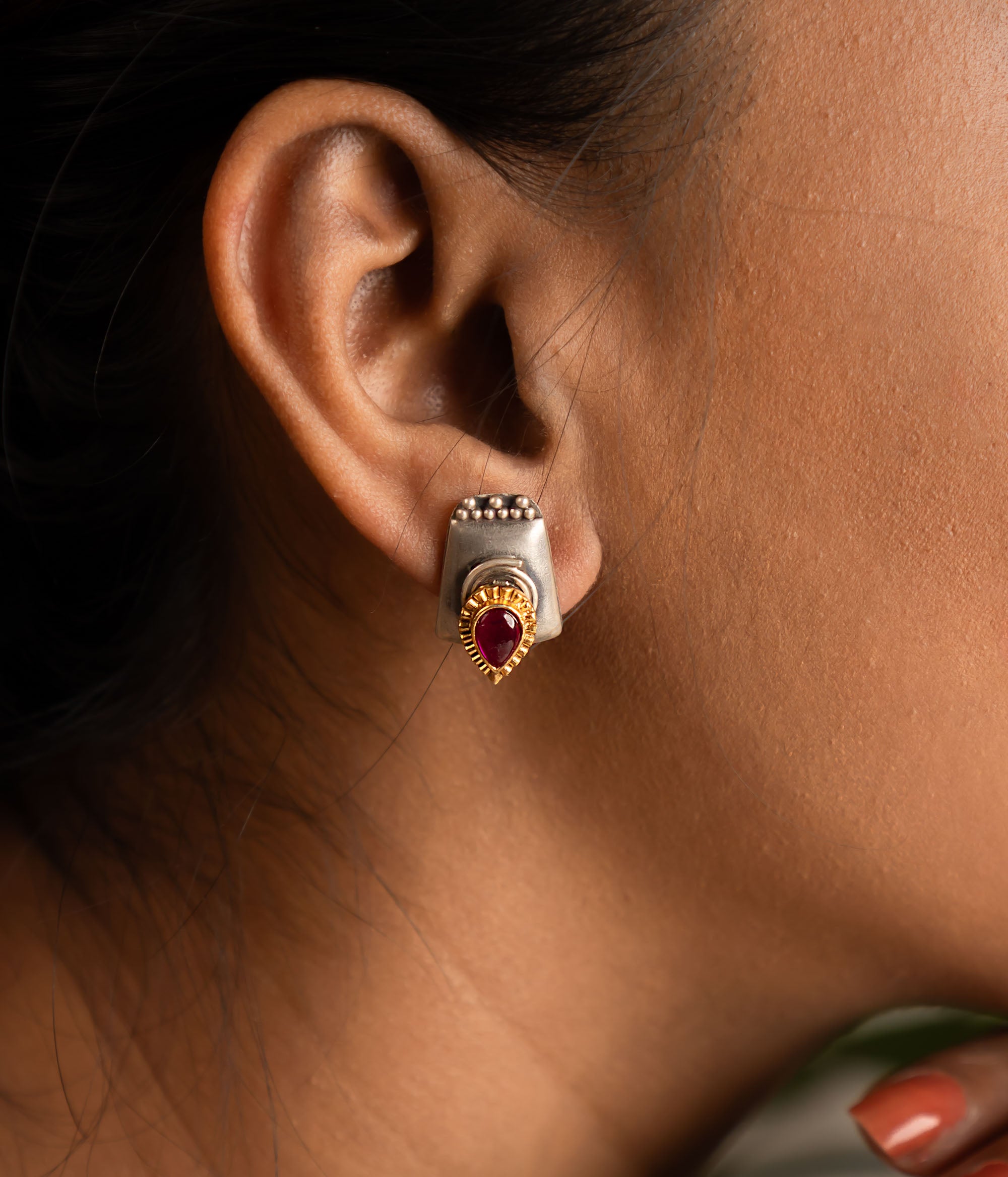 Crafted in oxidized silver with a radiant red spinel at the center, these stud earrings are a versatile statement of elegance and charm.