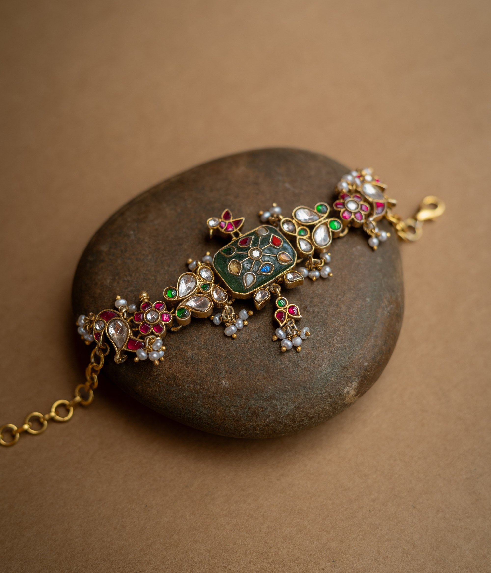 Multicolour stone and pearl-studded Hue Collection bracelet with rectangular centre and floral Kundan motifs.