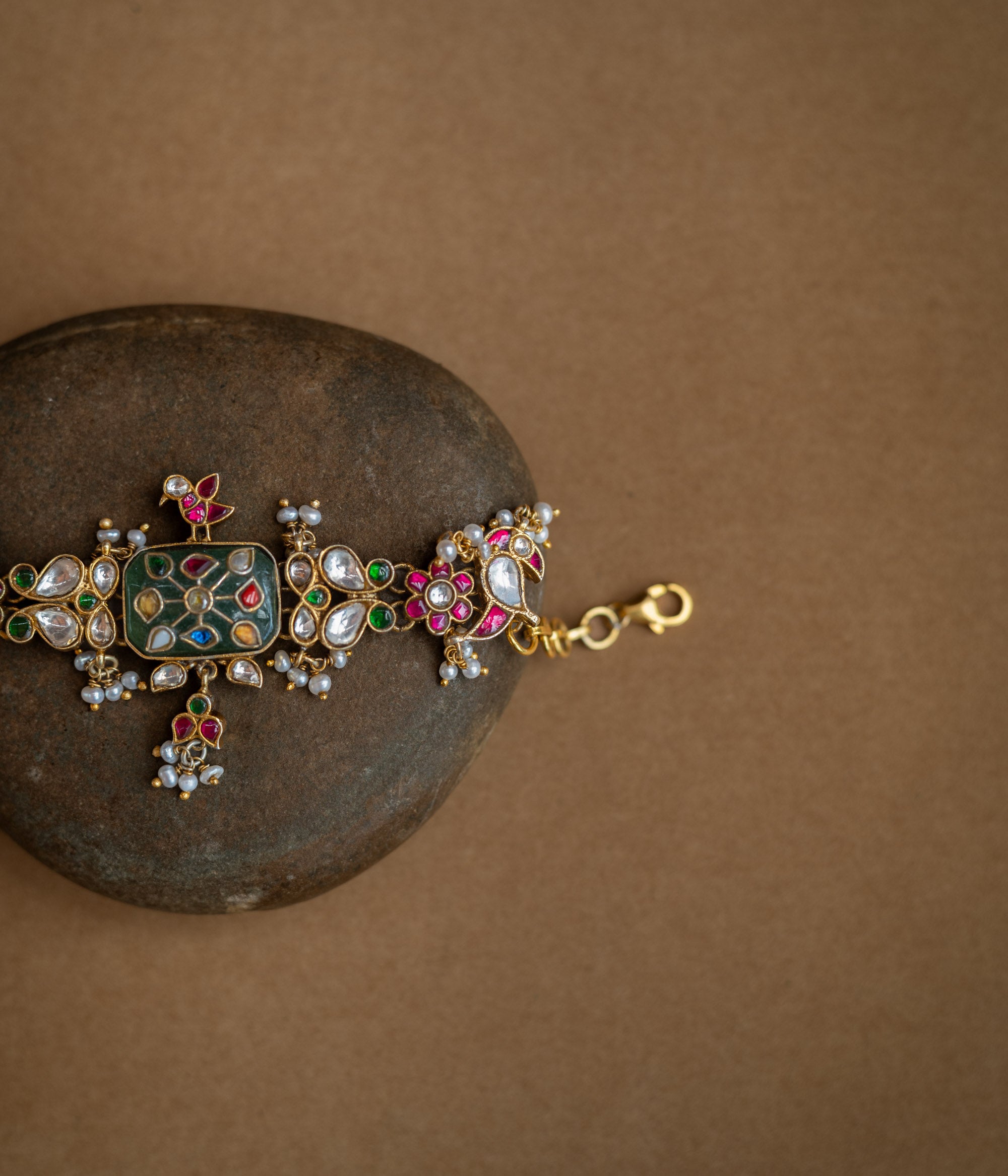 Multicolour stone and pearl-studded Hue Collection bracelet with rectangular centre and floral Kundan motifs.
