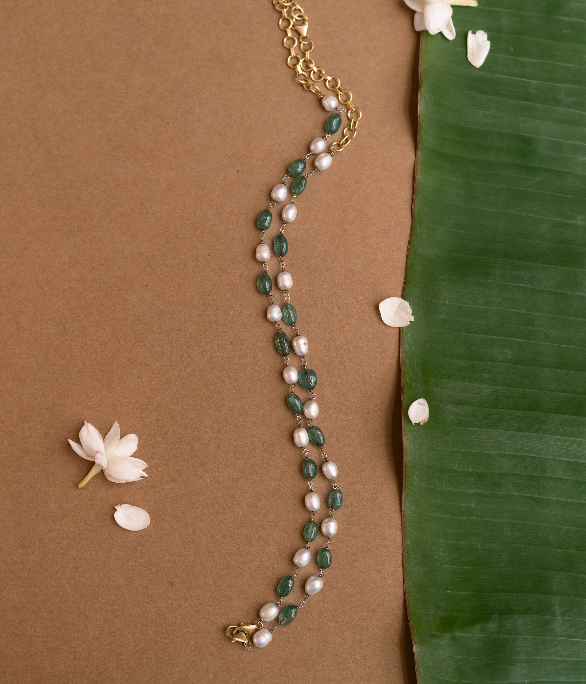 A long necklace made of alternating green and white beads.