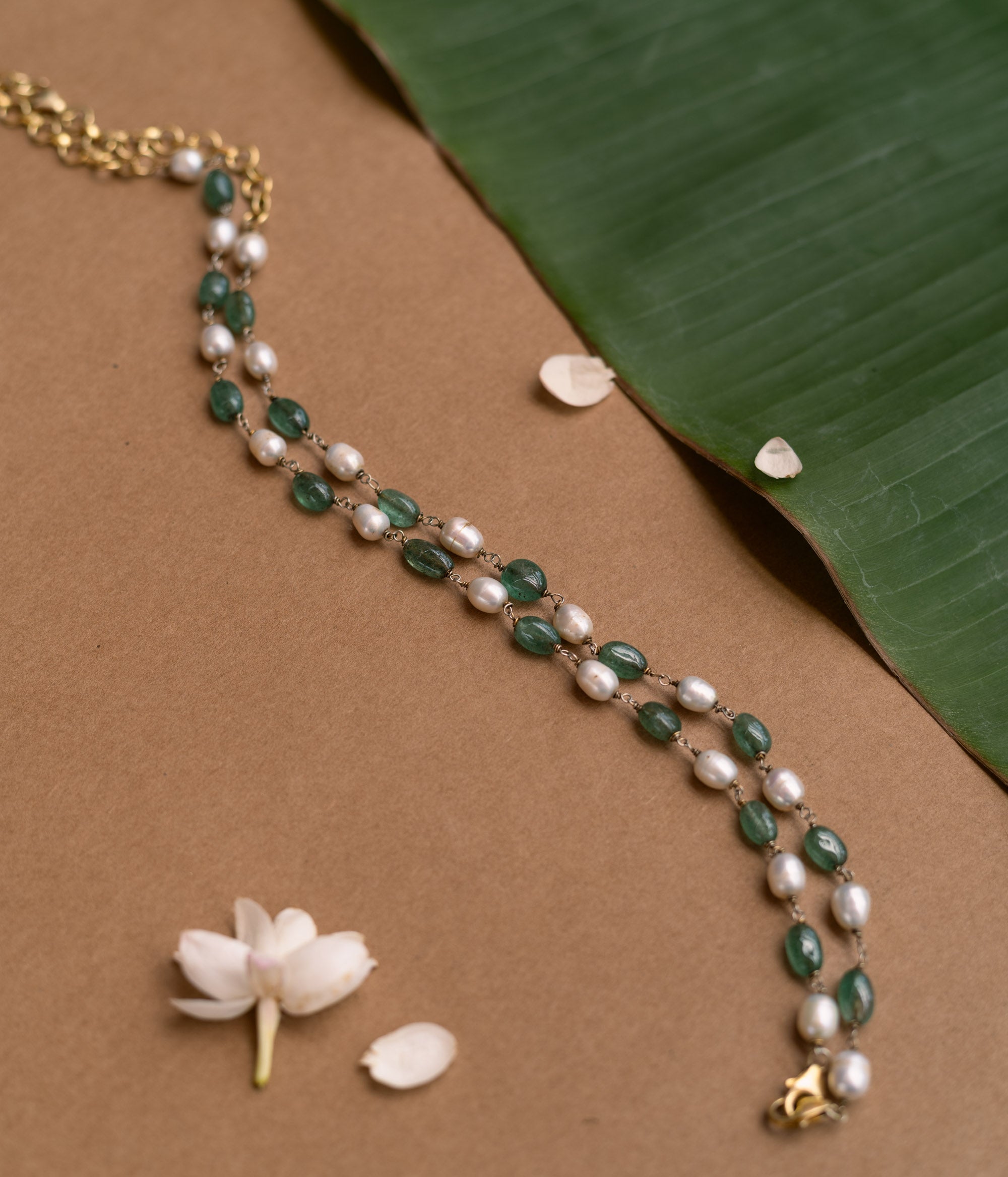 A long necklace made of alternating green and white beads.