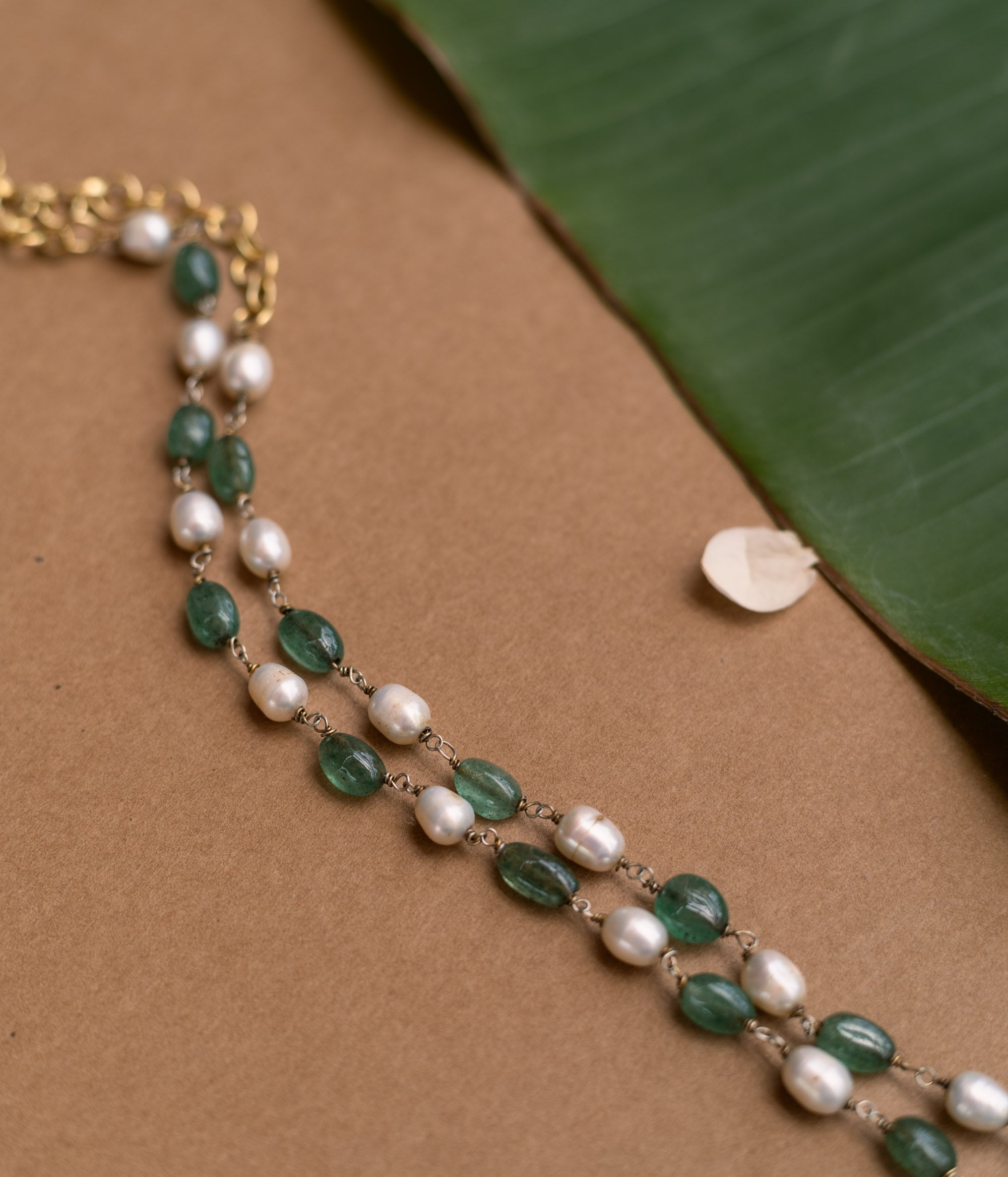 A long necklace made of alternating green and white beads.
