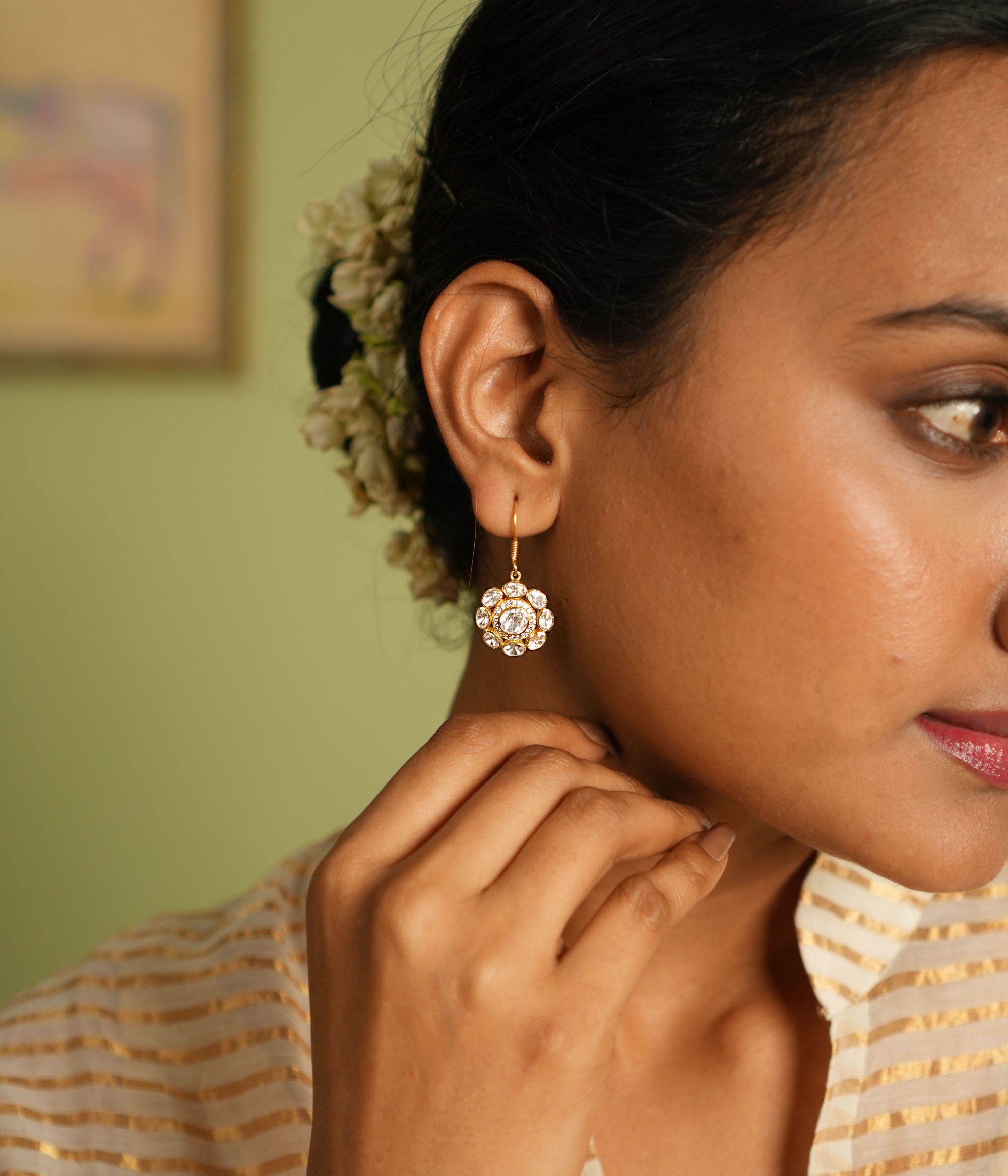 Elegant gold-plated silver floral earrings with a hook design, adorned with sparkling Polki stones, showcasing a timeless and sophisticated look perfect for any occasion.