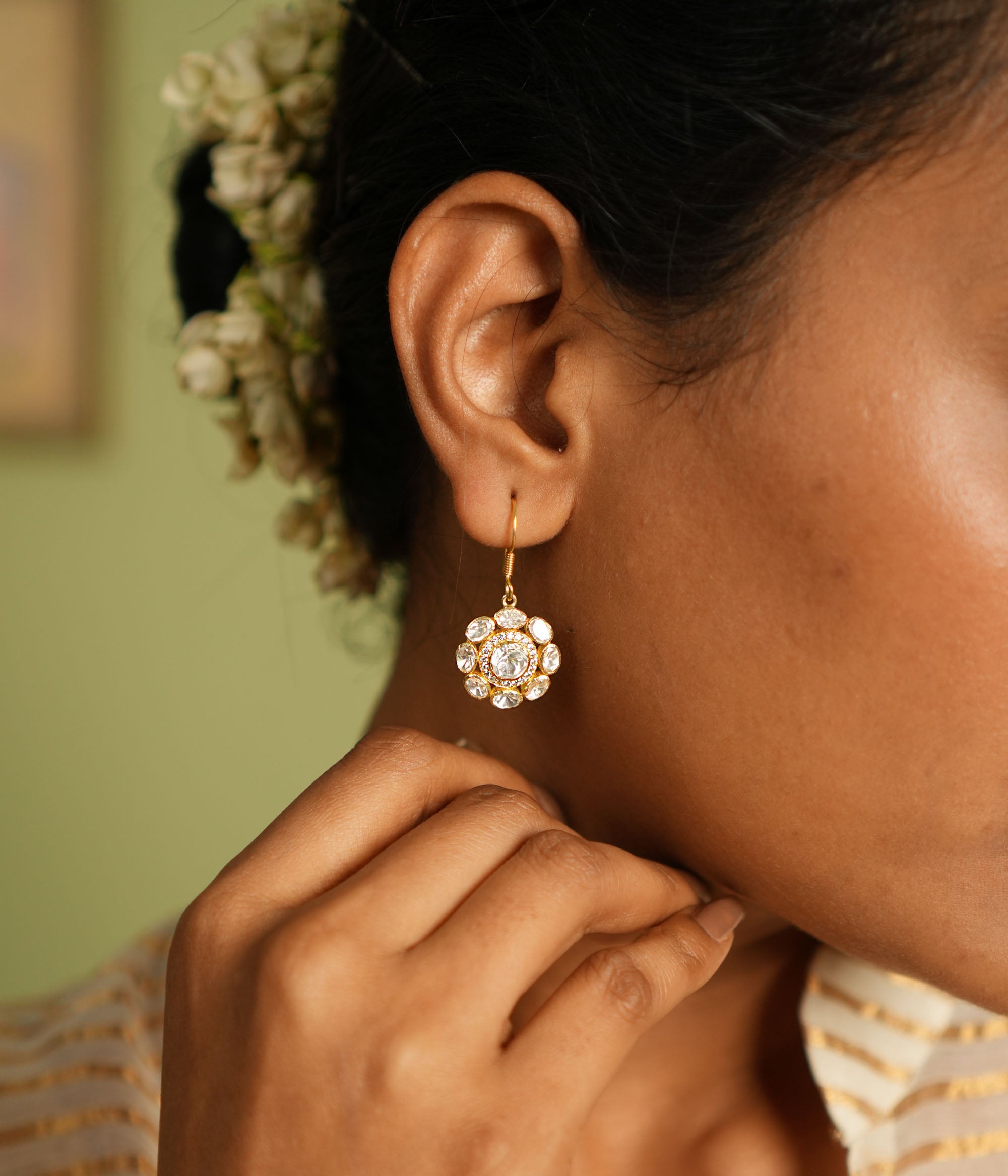 Elegant gold-plated silver floral earrings with a hook design, adorned with sparkling Polki stones, showcasing a timeless and sophisticated look perfect for any occasion.