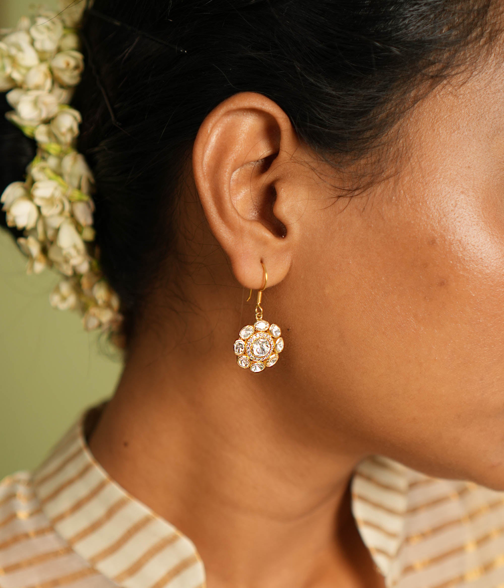 Elegant gold-plated silver floral earrings with a hook design, adorned with sparkling Polki stones, showcasing a timeless and sophisticated look perfect for any occasion.