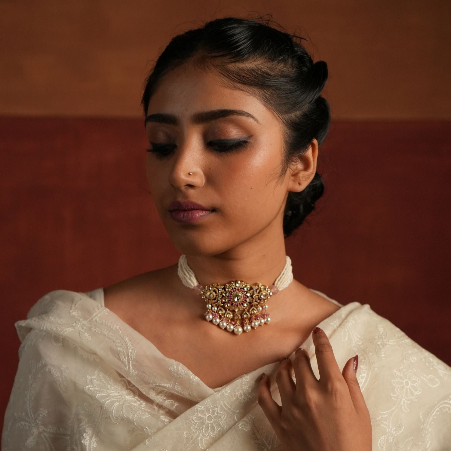 Elegant layered pearl choker featuring a floral-designed pendant adorned with Moissanite Polki Stones, CZ Stones, and Pink Stones. The pendant is beautifully accented with delicate drops of Rose Quartz and pearls, adding a touch of sophistication and grace.