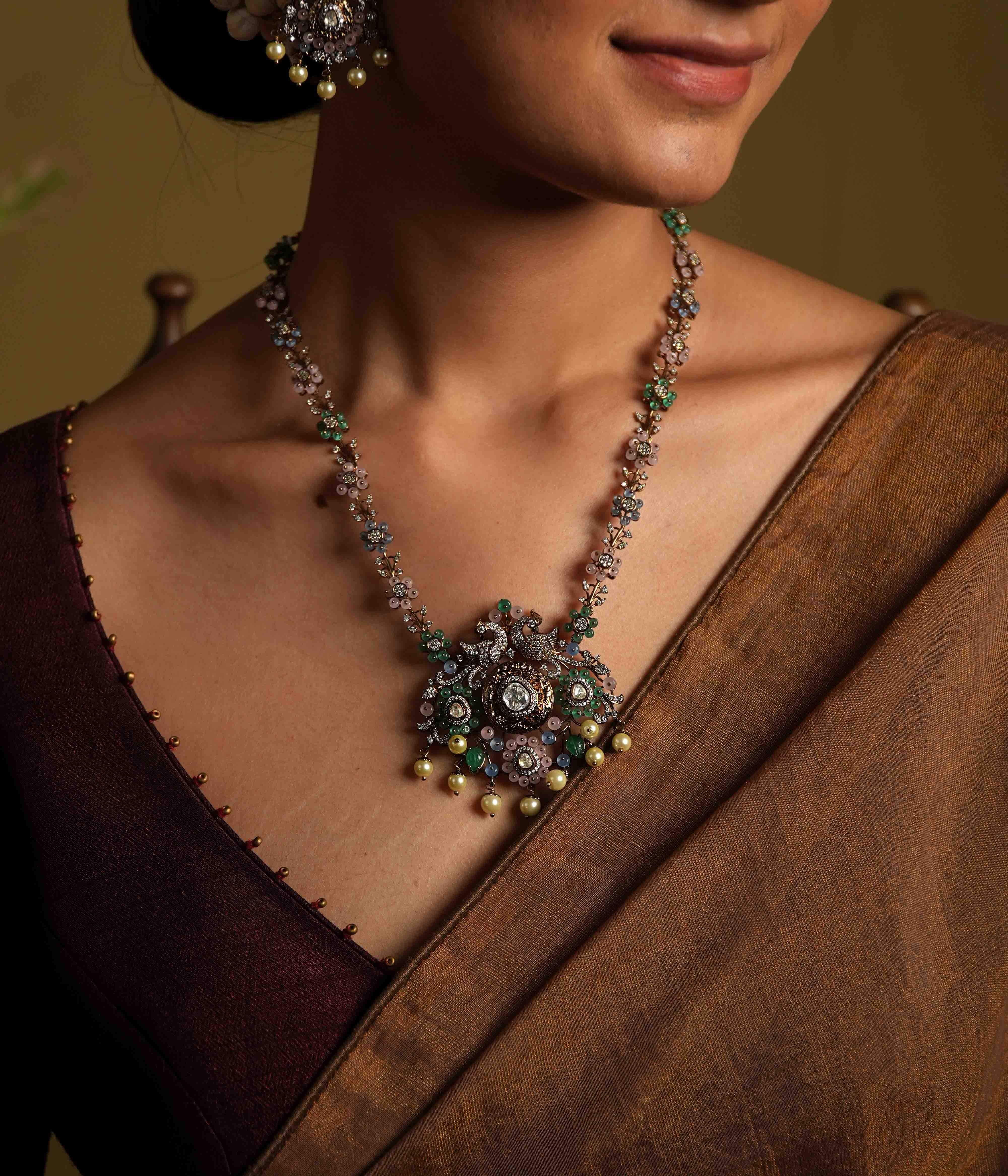 A handcrafted 92.5 sterling silver and 14ct dark antique gold-plated necklace, featuring CZ stones, polki stones, green beads, and pearls in a Victorian finish, showcasing intricate floral designs and a show-stopping double peacock moissanite pendant.