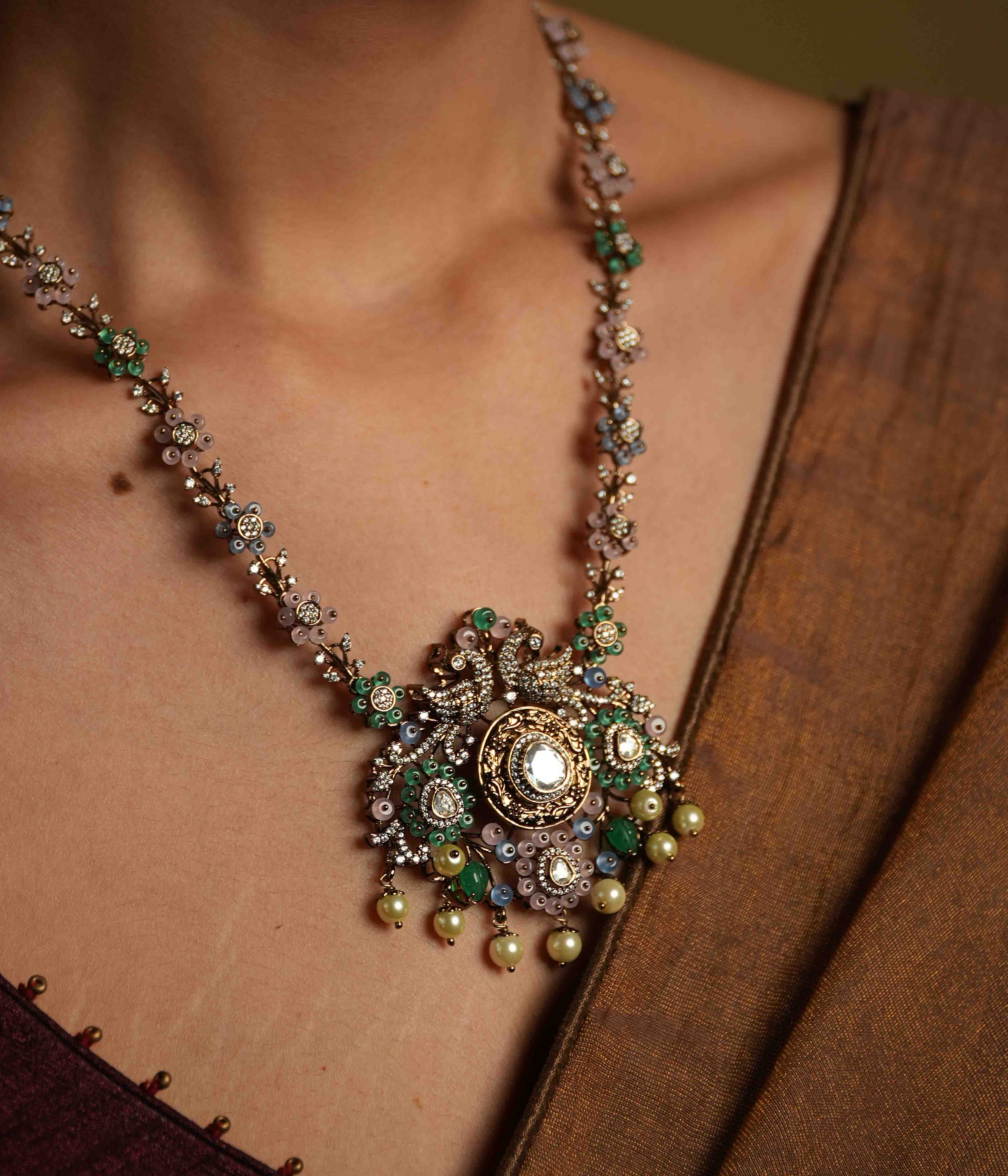 A handcrafted 92.5 sterling silver and 14ct dark antique gold-plated necklace, featuring CZ stones, polki stones, green beads, and pearls in a Victorian finish, showcasing intricate floral designs and a show-stopping double peacock moissanite pendant.