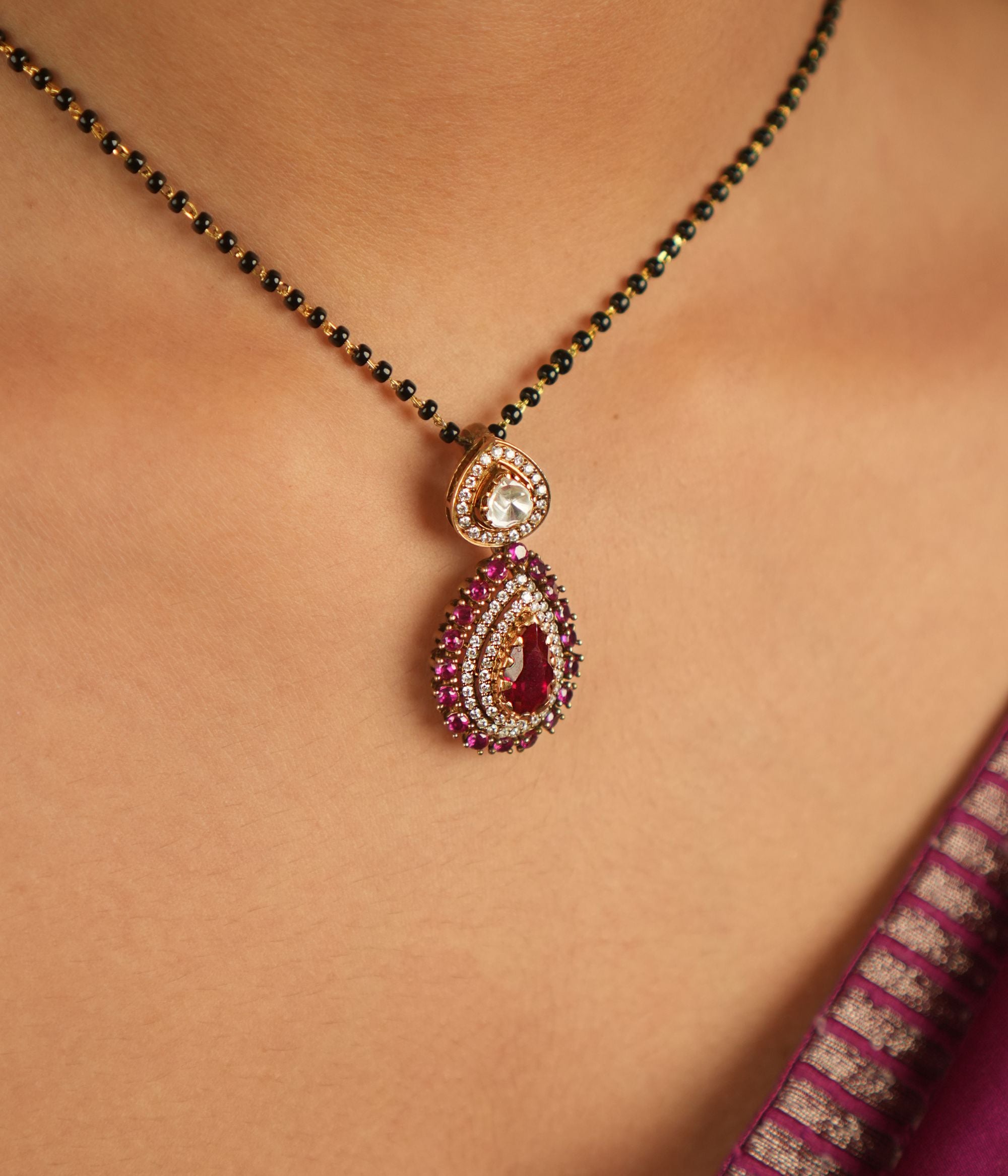 Enhance your jewelry collection with this exquisite teardrop pendant featuring dazzling Moissanite Polki stones, sparkling CZ stones, and a vibrant Red Garnet at its center. Designed with meticulous craftsmanship, this pendant offers a sophisticated touch of elegance, making it a perfect addition to your collection.