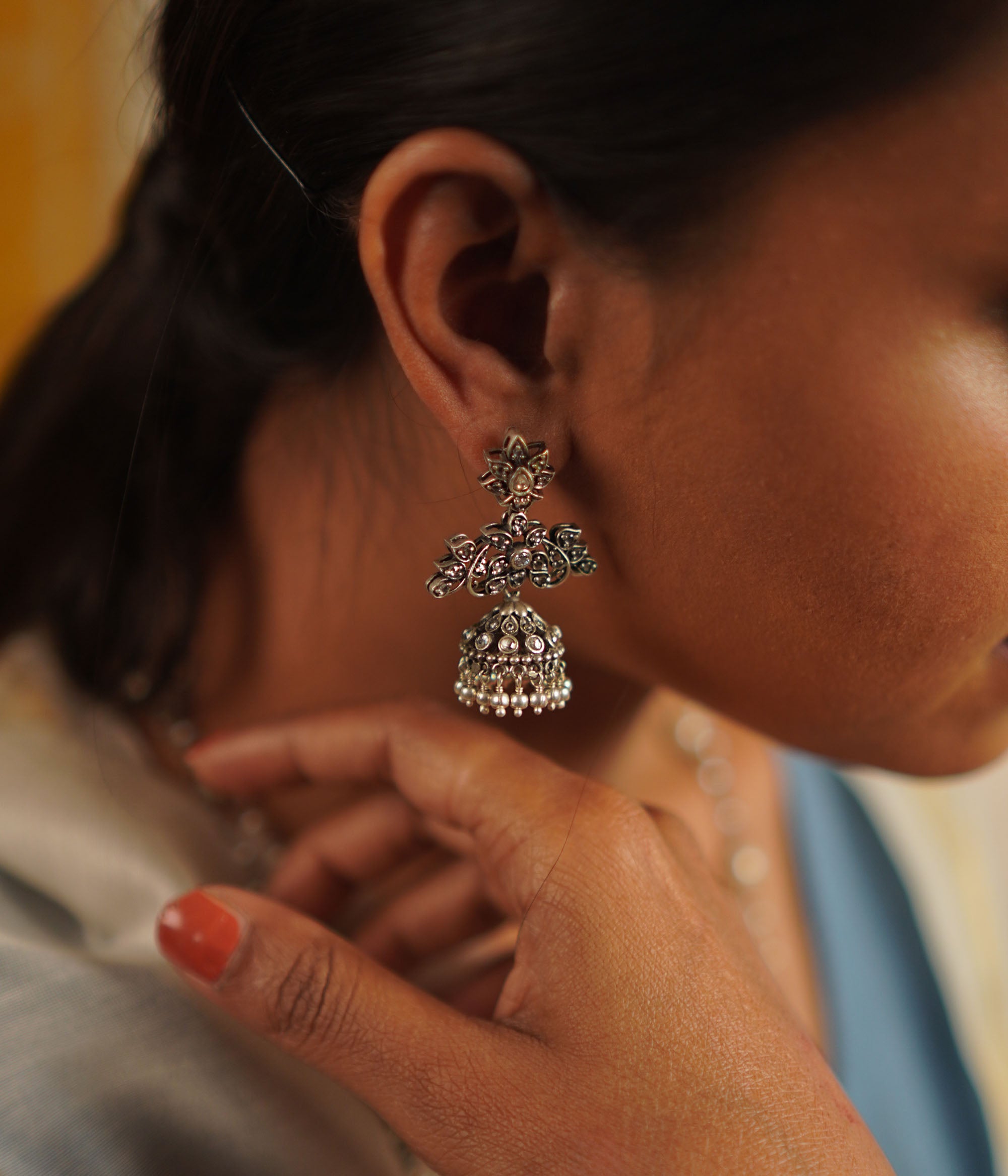 The Heti earrings, meticulously handcrafted in oxidized silver, showcase intricate detailing that reflects the essence of Indian heritage. Embellished with radiant white kundan stones, these jhumkas seamlessly blend tradition with contemporary elegance.