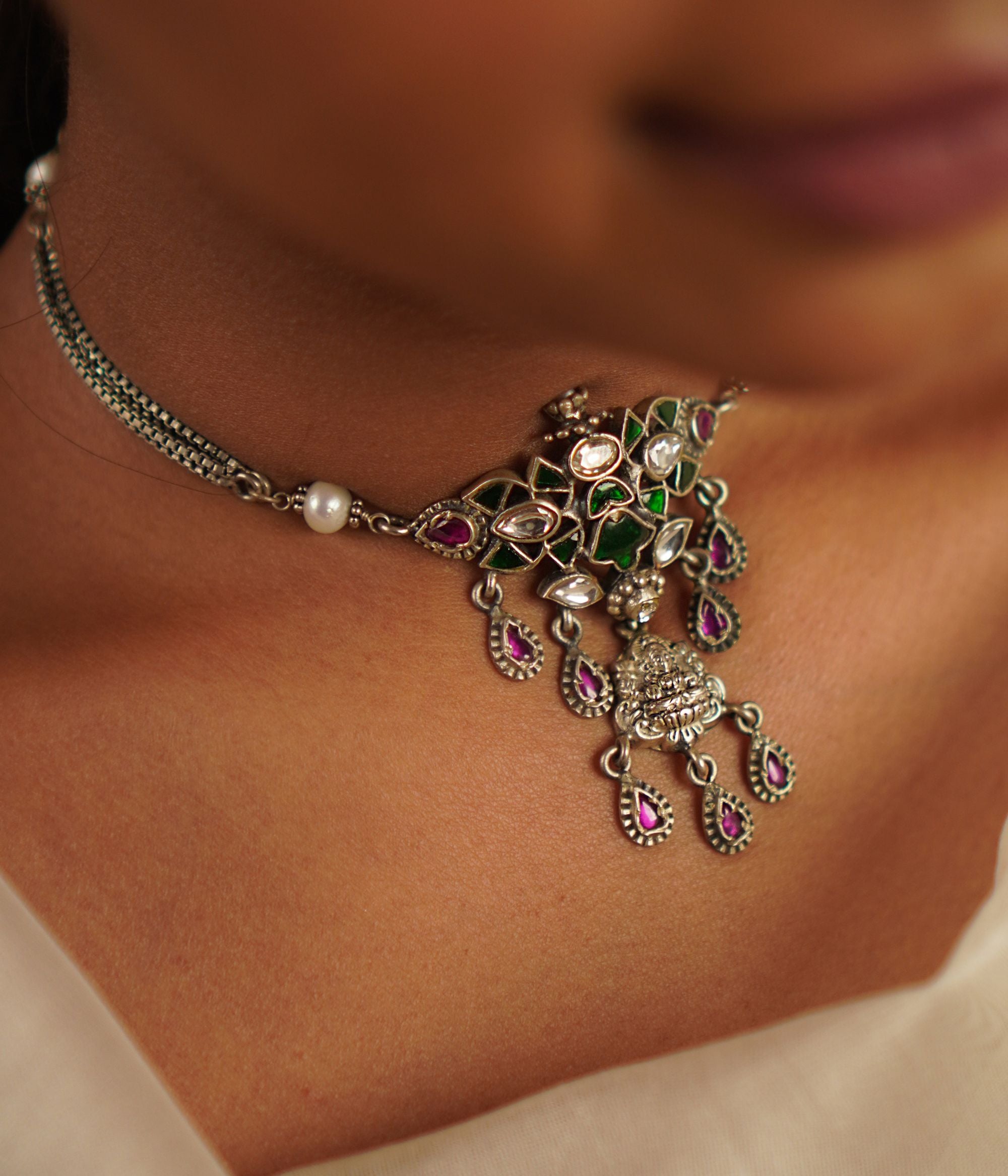 This oxidized silver choker, embellished with radiant kundan stones and delicate pearls, captures the essence of a treasured heirloom. A seamless fusion of heritage and charm, it embodies timeless grace with a hint of whimsy.