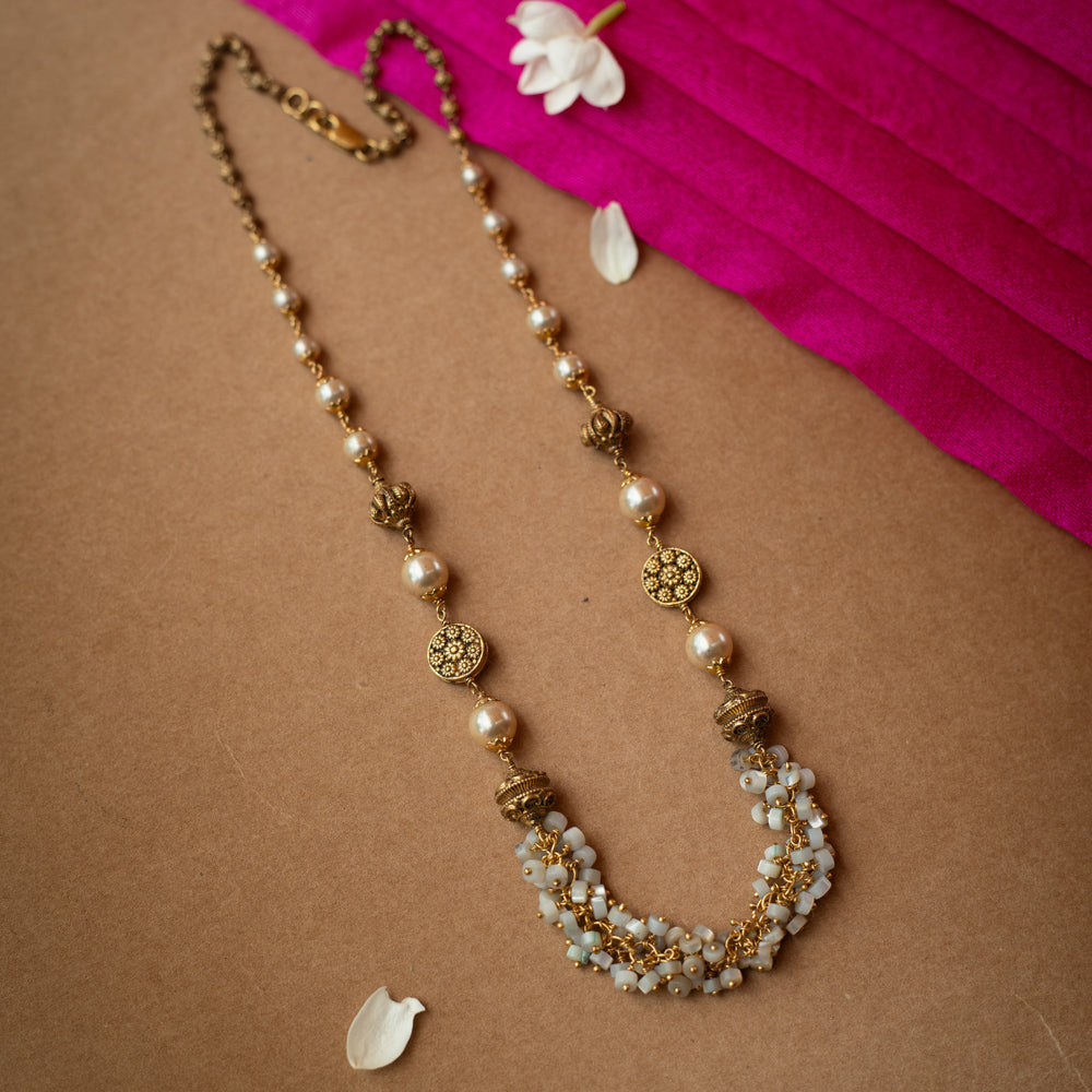 A multi-strand chain necklace made entirely of white pearls.