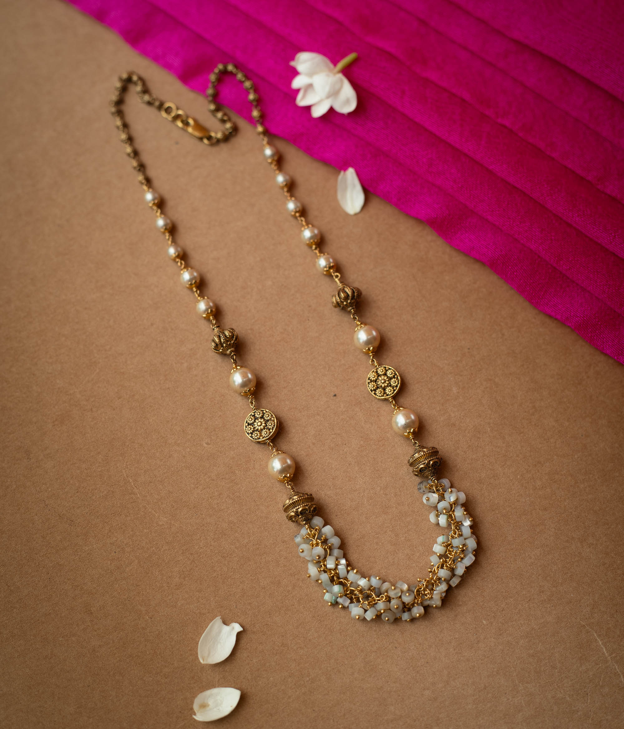 A multi-strand chain necklace made entirely of white pearls.