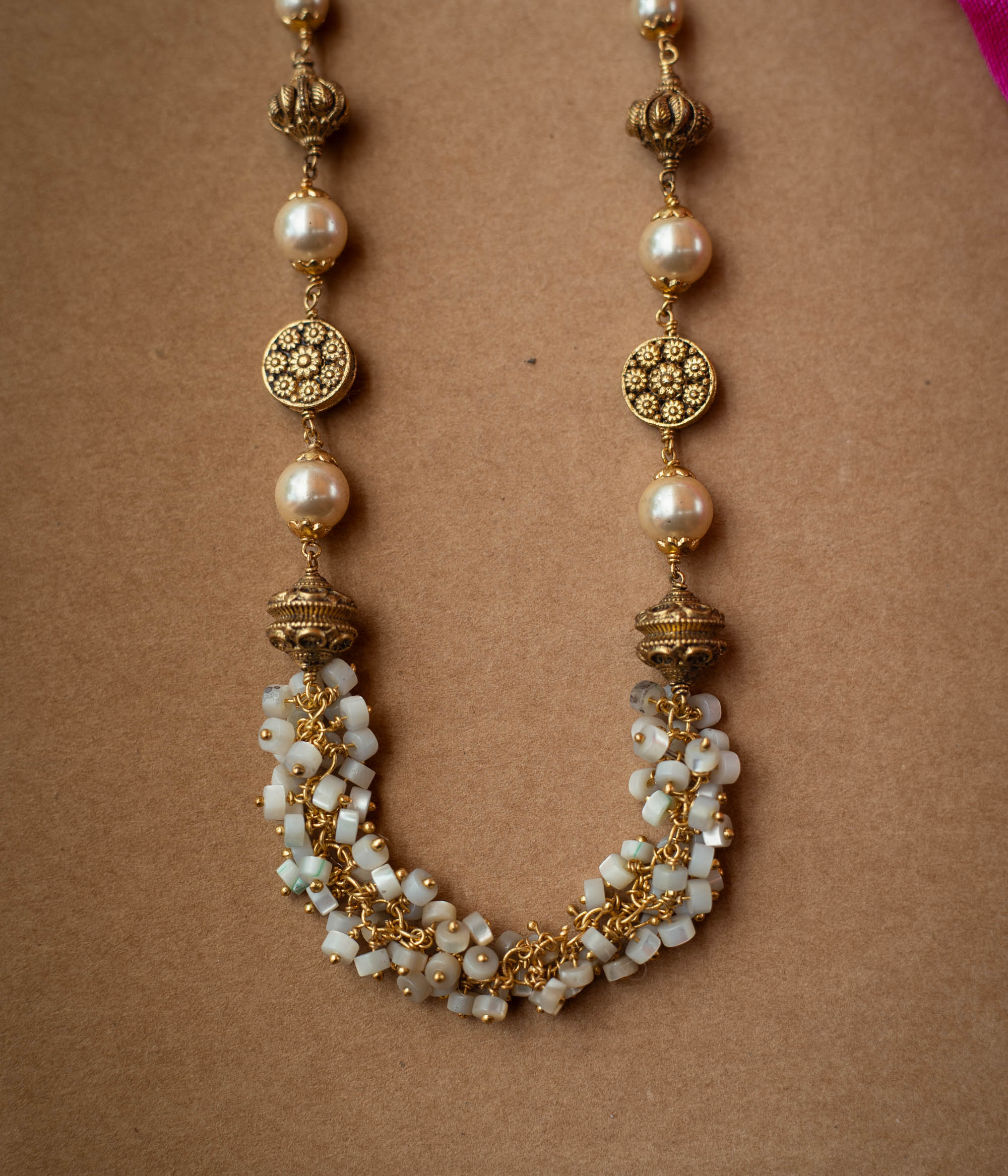 A multi-strand chain necklace made entirely of white pearls.