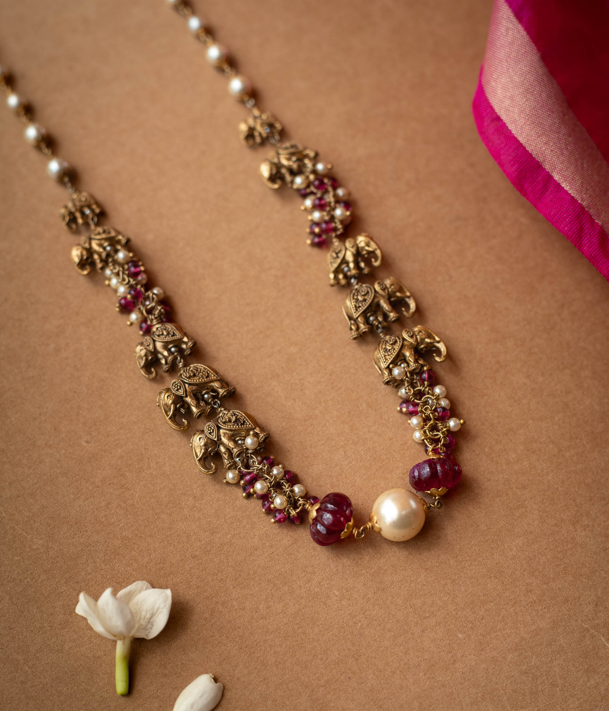 A two-strand chain with a strand of red beads and a strand of pearls.