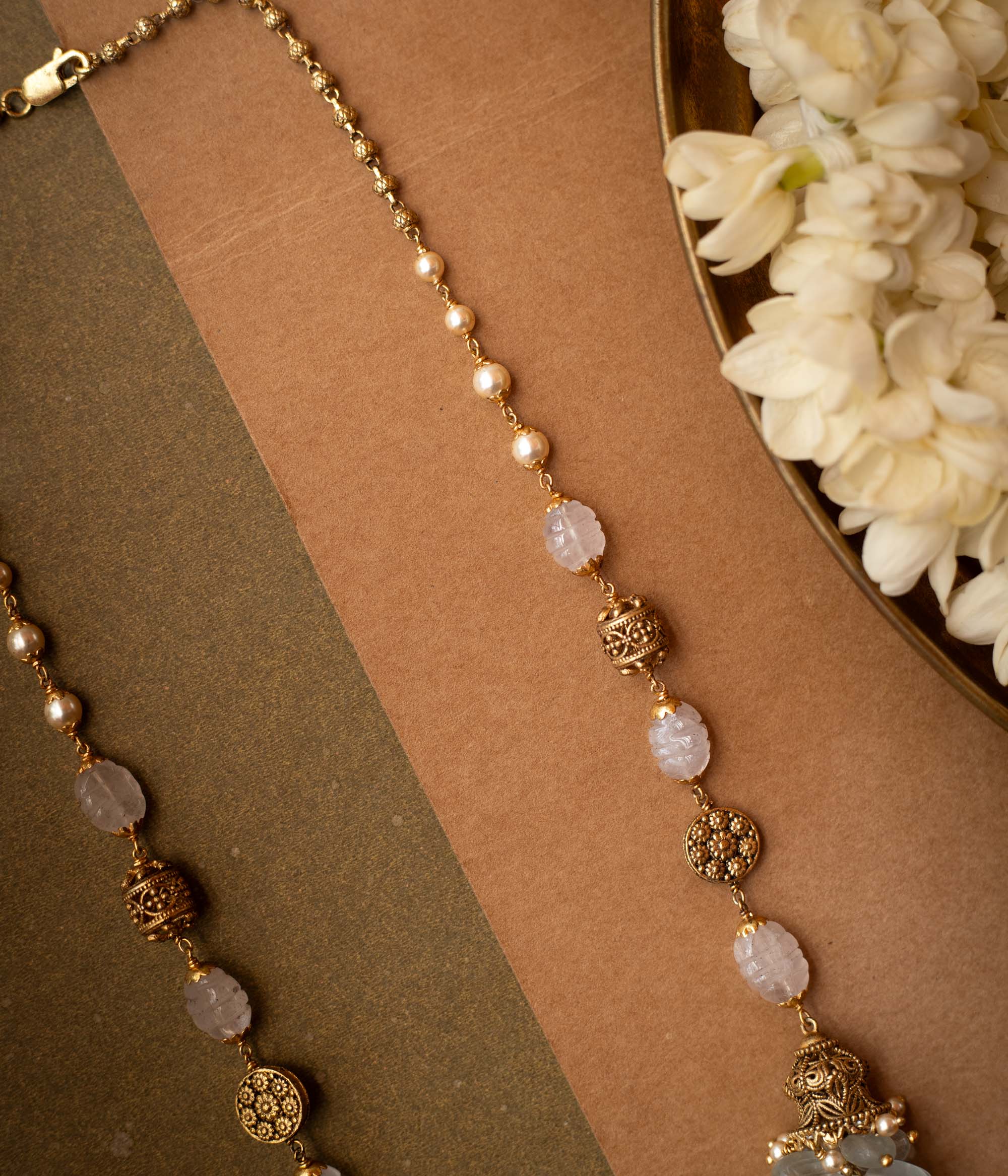 A thick, braided multi-strand chain necklace made entirely of white pearls.