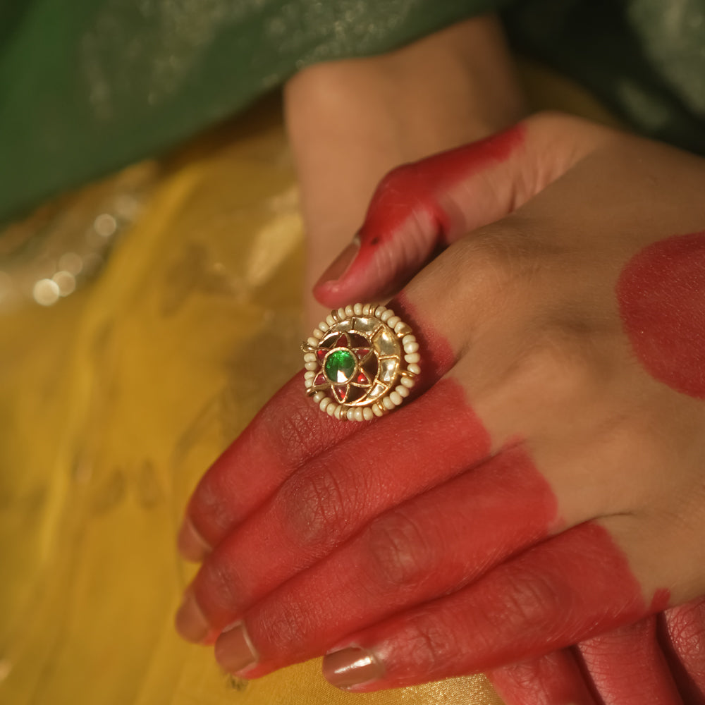 Gold-plated silver ring with a central green gem and beaded petals.