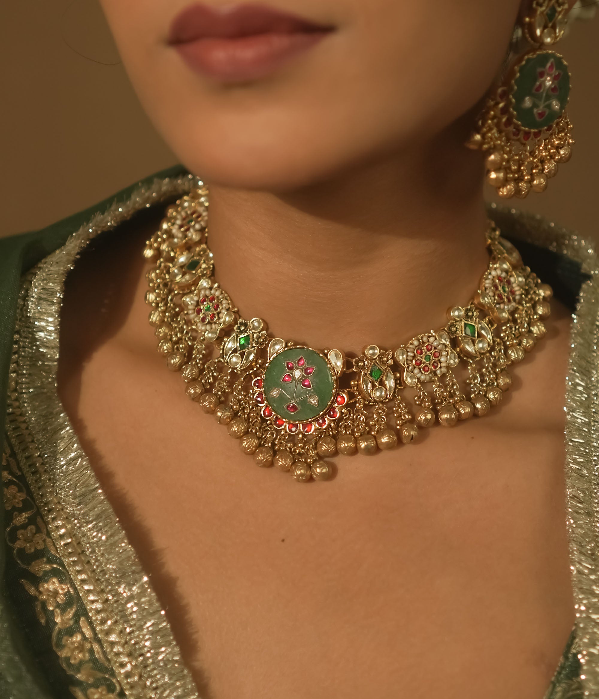 Gold-plated necklace with green enamel medallions, crimson jewels, and pearls.