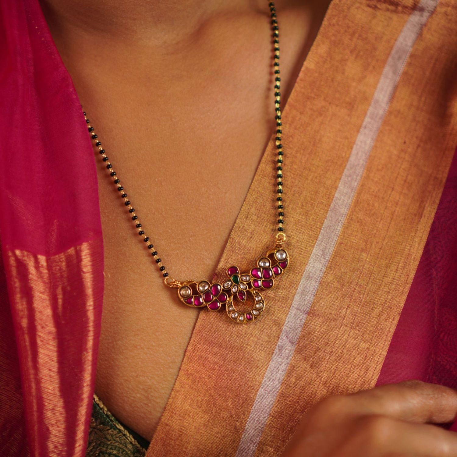 The Jaba Mangalsutra, handcrafted in gold-plated silver, showcases vibrant kundan stones paired with traditional black beads. A timeless design with a modern twist, it beautifully blends heritage craftsmanship with contemporary elegance.