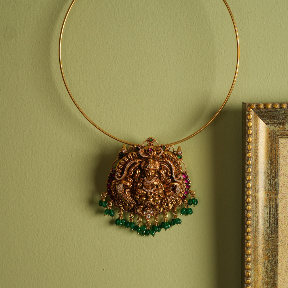 Traditional gold-plated silver temple jewelry pendant featuring Goddess Lakshmi at the center, adorned with radiant red and green Kundan stones and elegant strawberry quartz drops. Designed with both single and double hooks for versatile styling, this pendant exudes divine grace and timeless craftsmanship.