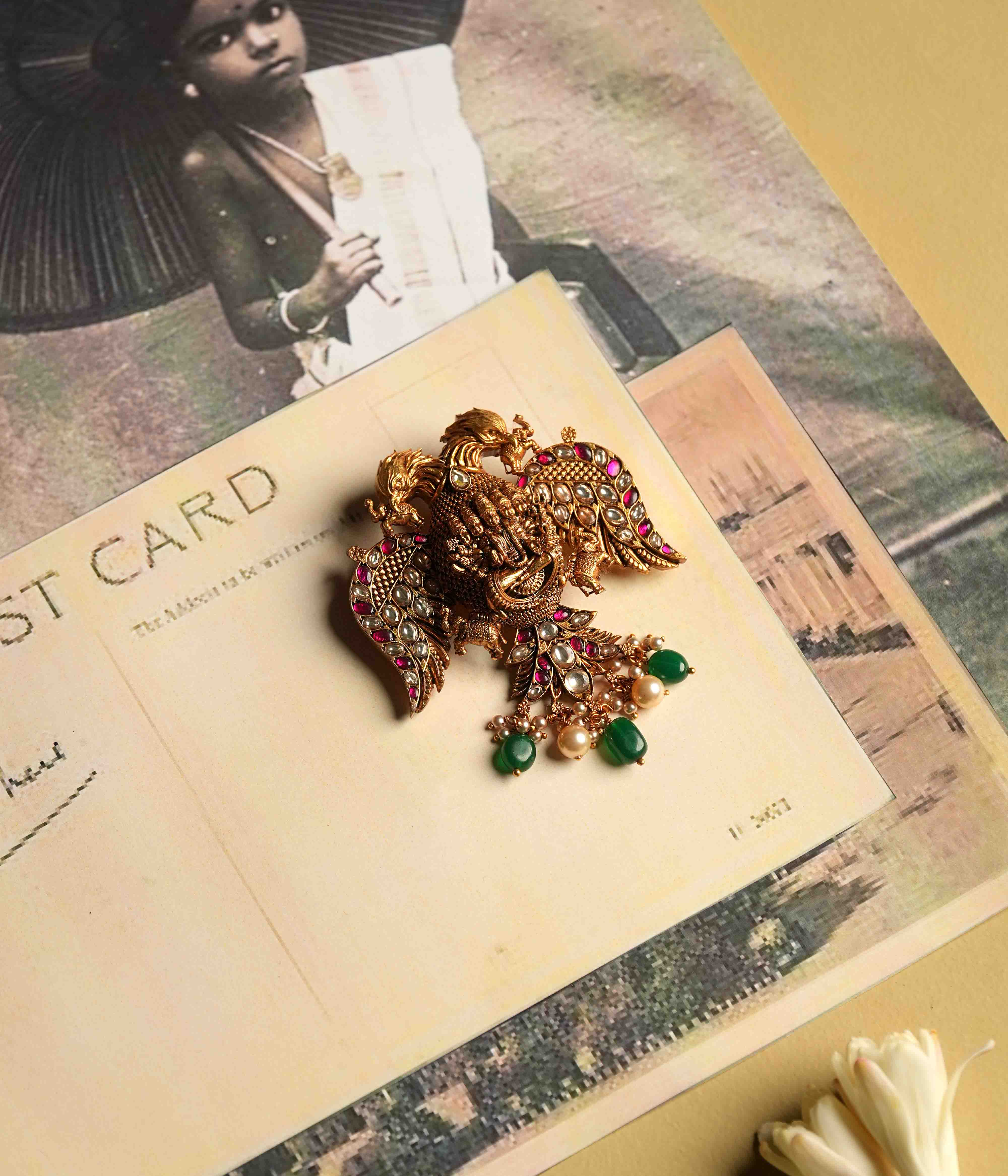 An antique gold-plated 92.5 sterling silver pendant, featuring intricate deity and double eagle engravings, showcases red and white Kundan stones, evoking the mystique of ancient temples.
