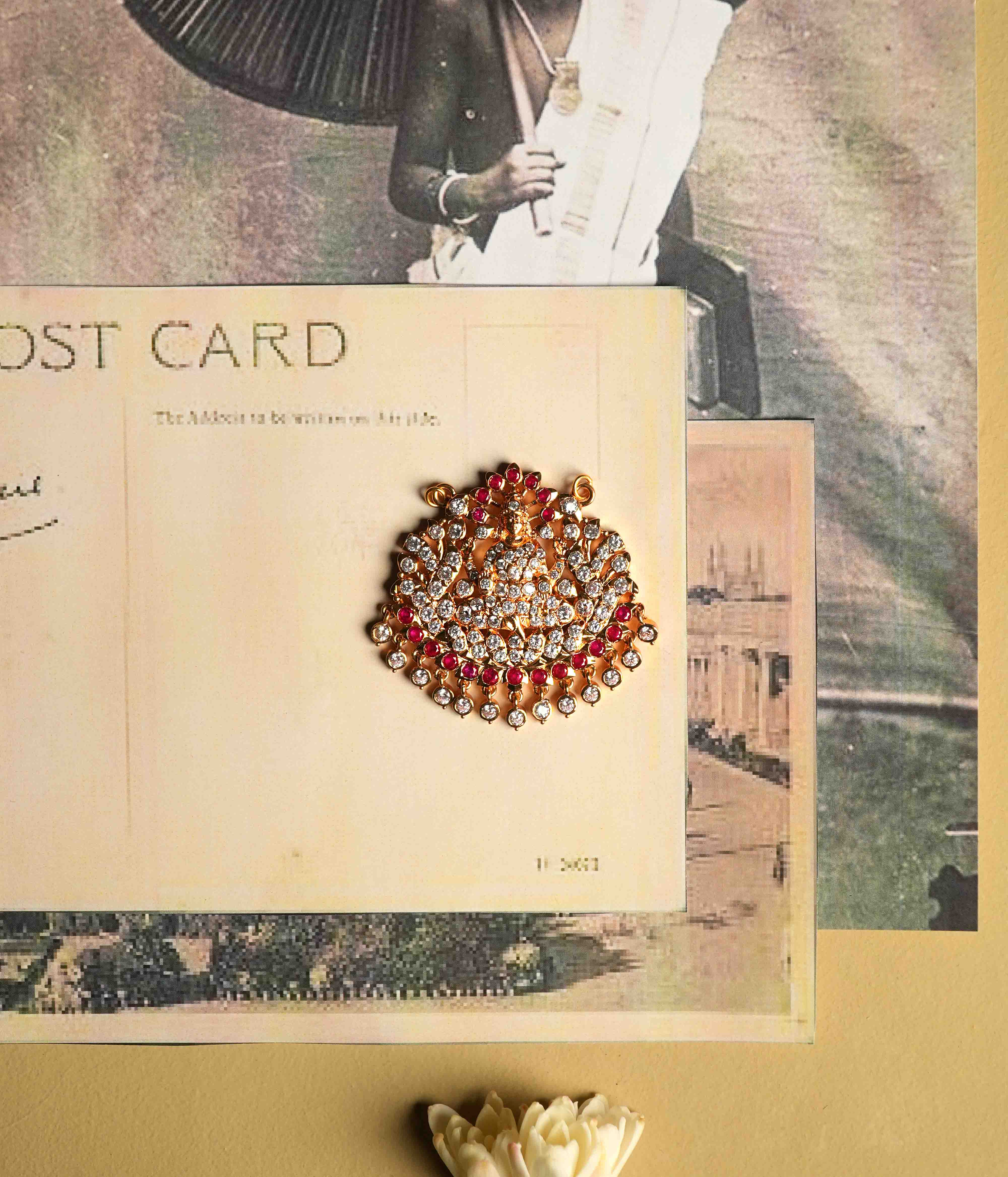This moissanite pendant, crafted from 92.5 sterling silver with a South screw fastening, showcases an intricate deity motif accented with red cut stones and Swarovski crystals, inspired by vintage Chettinad stone settings.