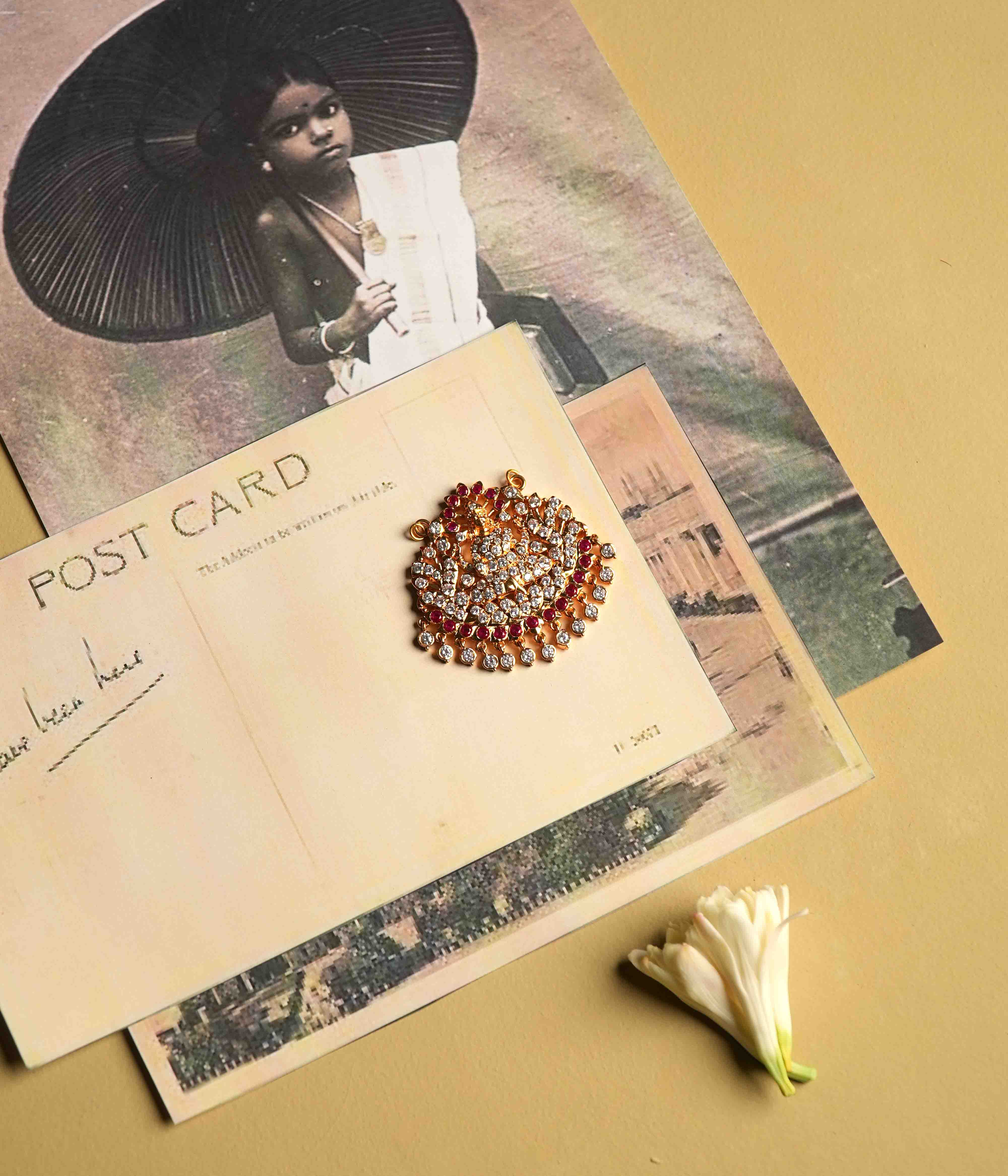 This moissanite pendant, crafted from 92.5 sterling silver with a South screw fastening, showcases an intricate deity motif accented with red cut stones and Swarovski crystals, inspired by vintage Chettinad stone settings.