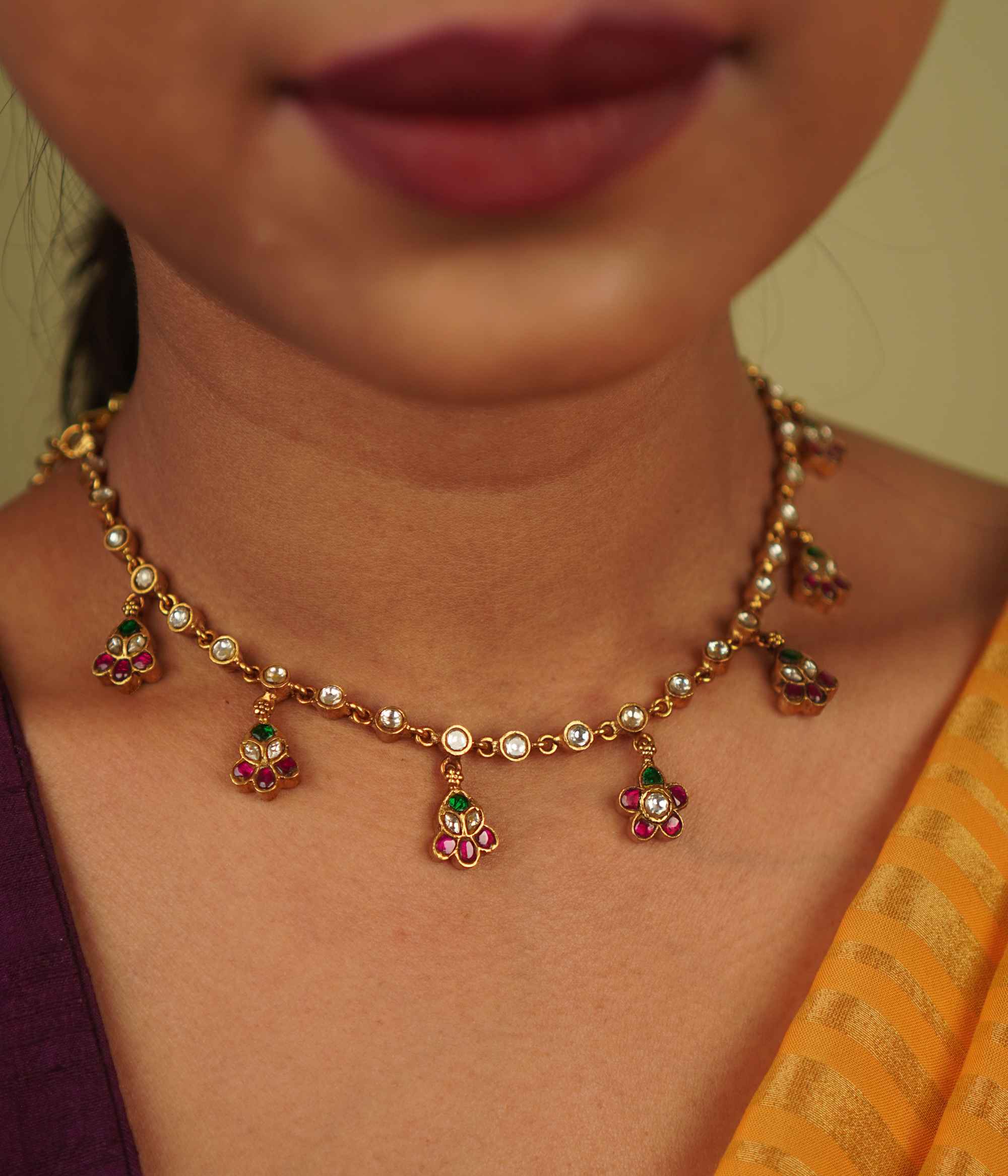 Jasmira Necklace: Graceful floral droplets adorned with red, white, and green kundans, set in gold-plated silver—timeless elegance redefined.