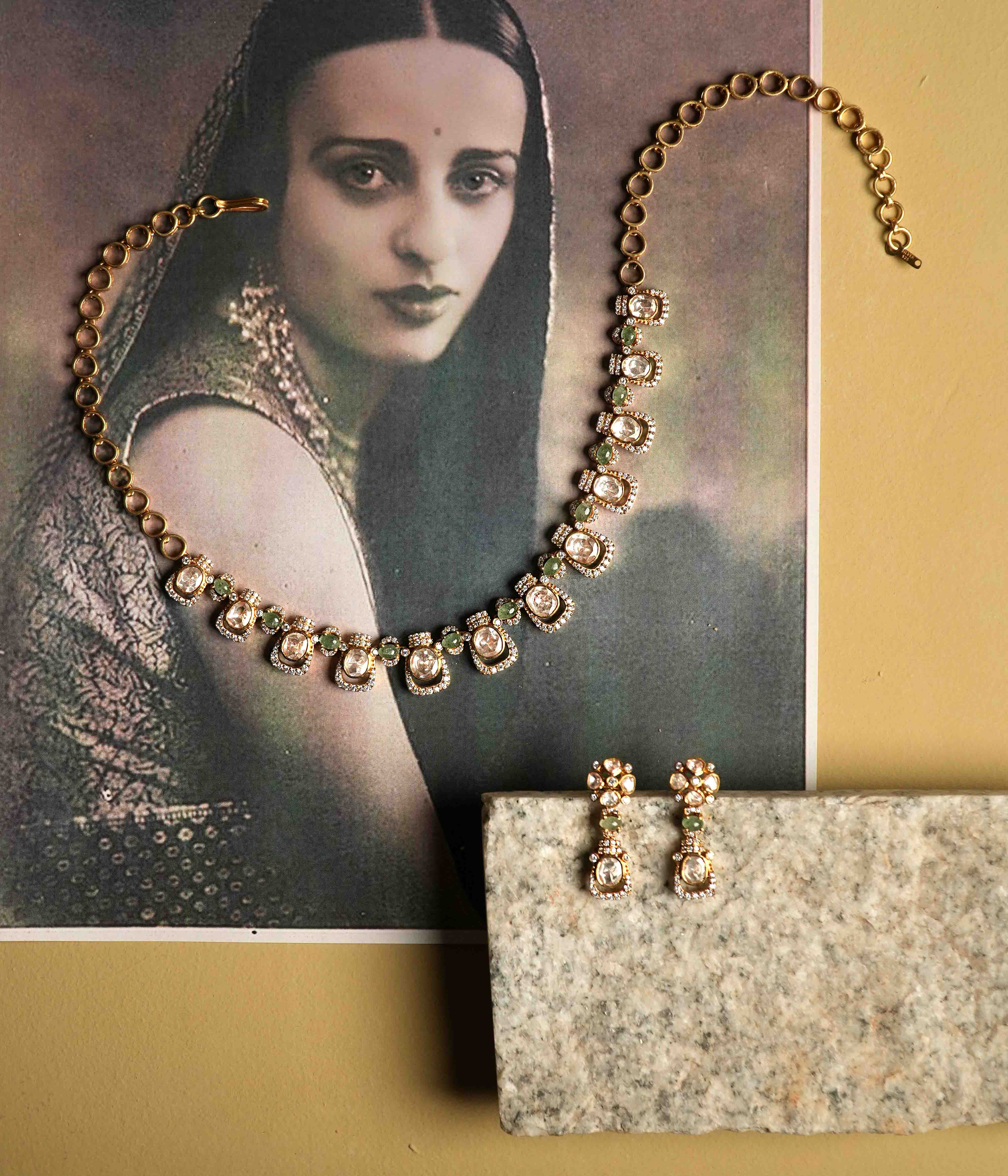 A delicate polki and moissanite necklace with matching drop earrings, crafted from handmade 92.5 sterling silver with 22ct gold plating, and accented with green tourmaline cut stones and CZ stones, embodying urban elegance and contemporary luxury.
