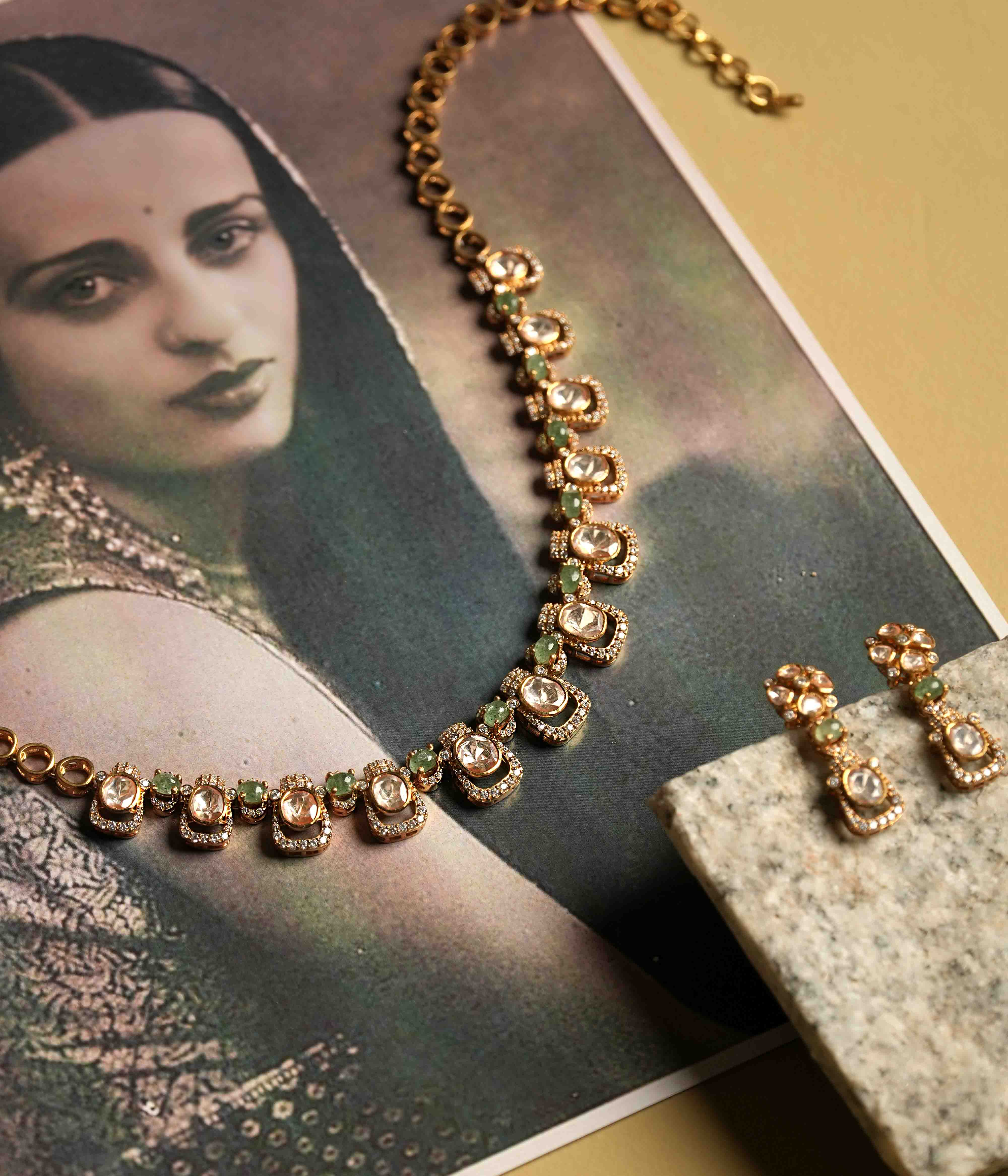 A delicate polki and moissanite necklace with matching drop earrings, crafted from handmade 92.5 sterling silver with 22ct gold plating, and accented with green tourmaline cut stones and CZ stones, embodying urban elegance and contemporary luxury.