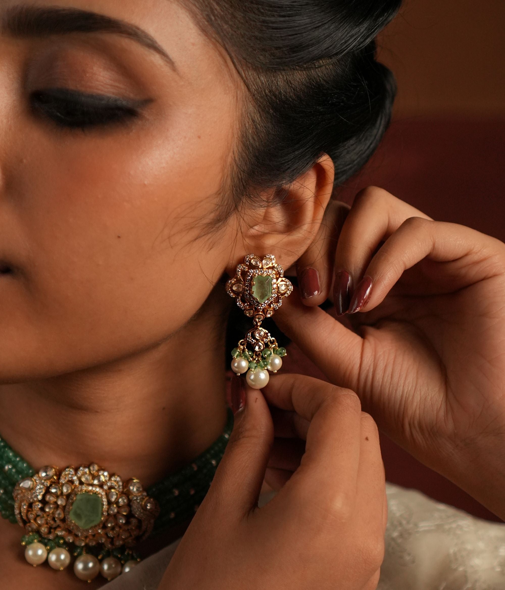 Elegant gold-plated silver drop earrings featuring Moissanite Polki Stones and Green Jade, exuding vintage charm with intricate filigree detailing. The Polki and Moissanite stones gracefully surround a vibrant green gemstone center, creating a timeless and sophisticated look.