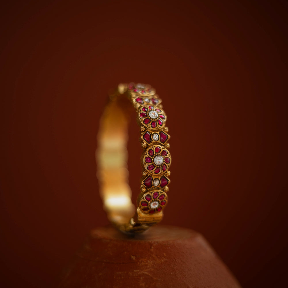 Gold bangle with red and white Kundan stones in floral pattern from Kundan collection.