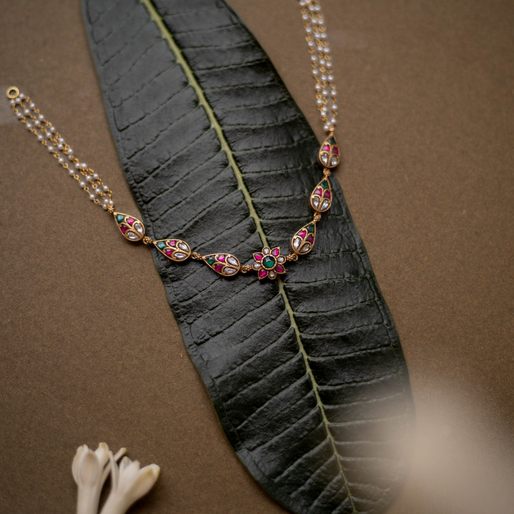 Floral kundan choker with red, green, and white stones and pearl dual chains.
