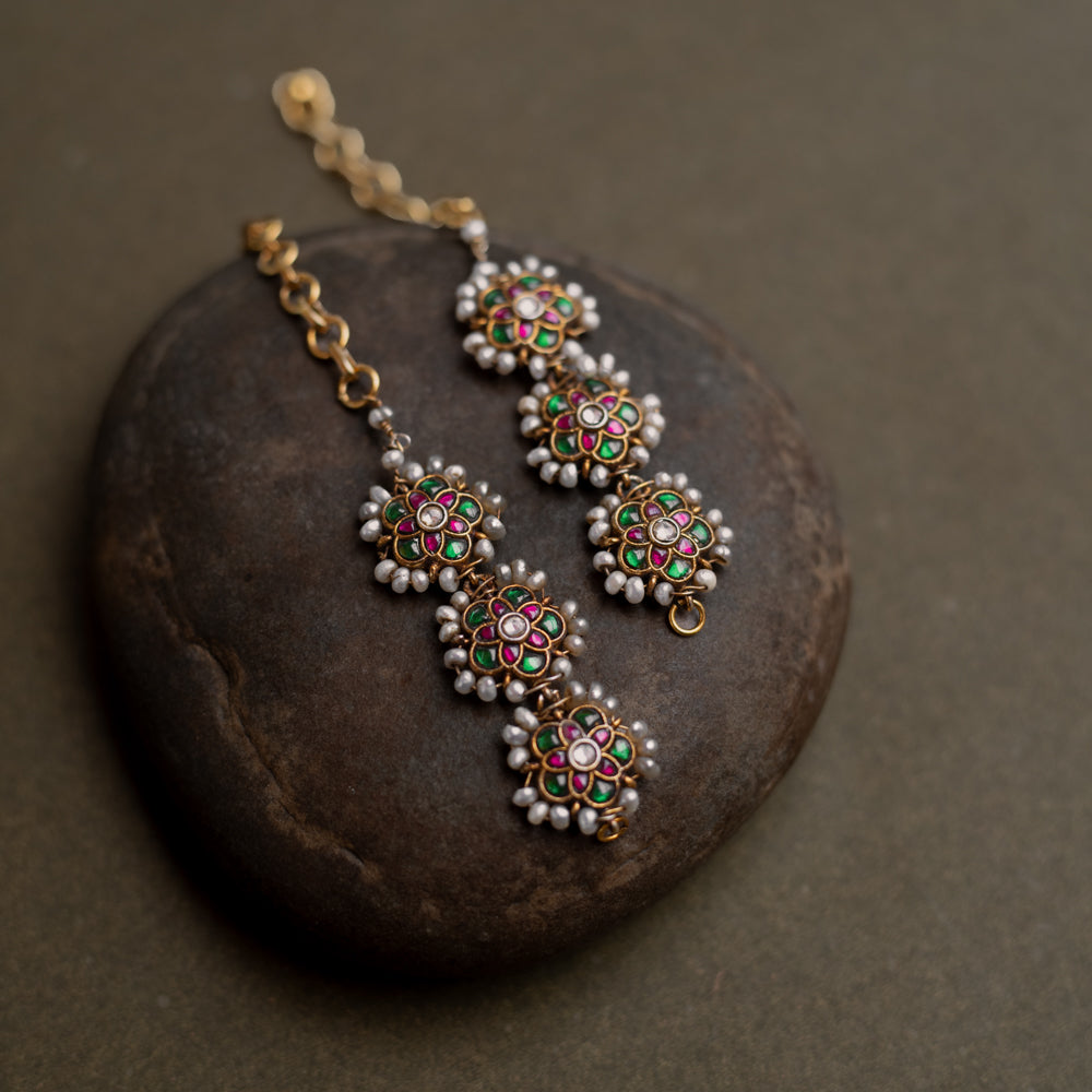 Kundan Collection ear chain with red, green, and white kundan stones enhanced with pearls in regal design.