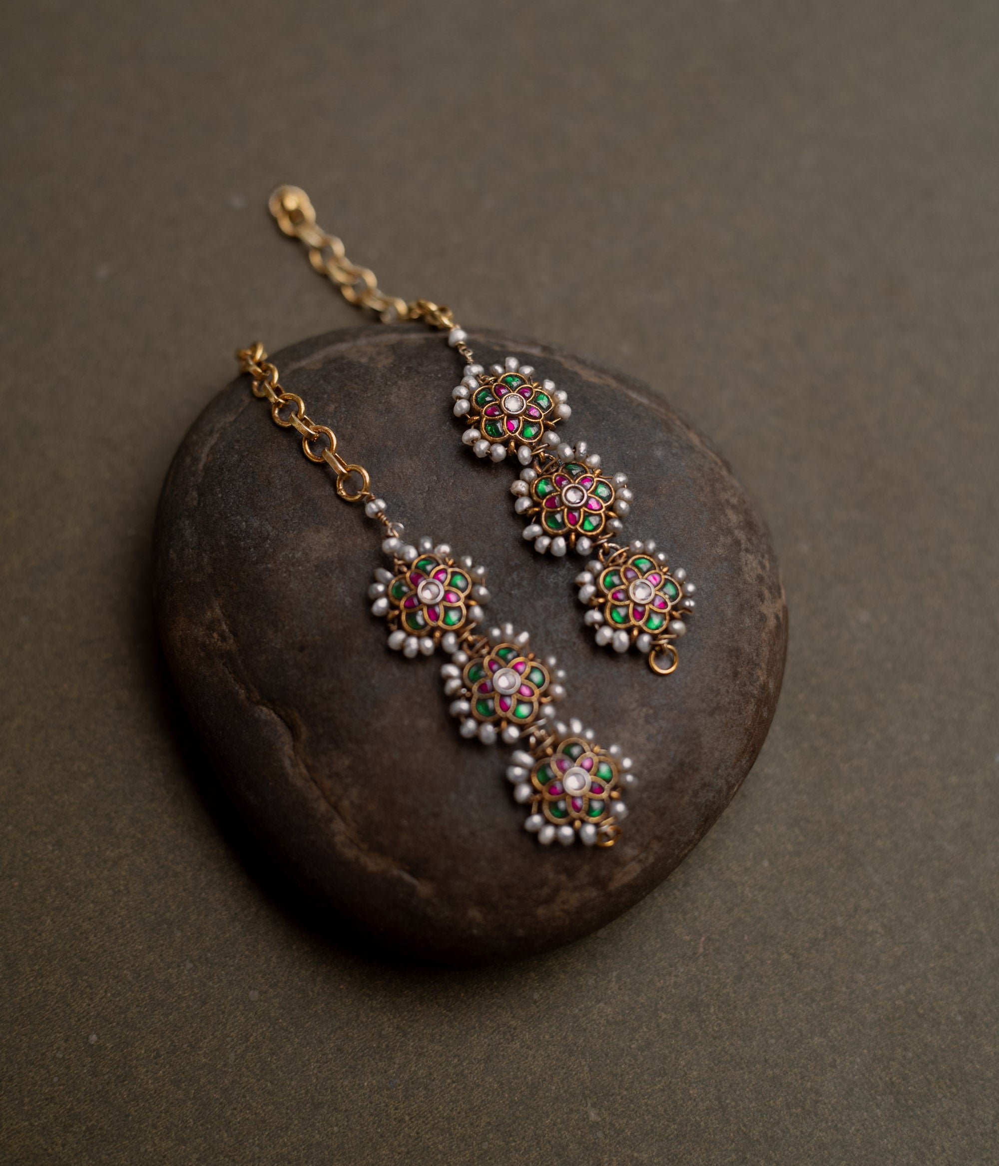 Kundan Collection ear chain with red, green, and white kundan stones enhanced with pearls in regal design.