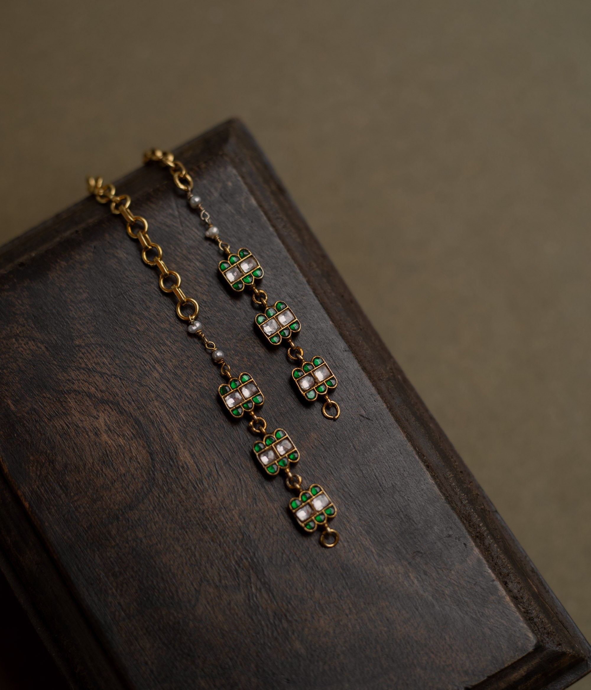 Kundan Collection ear chain with green kundan petals and white kundan stones in blooming vine design.