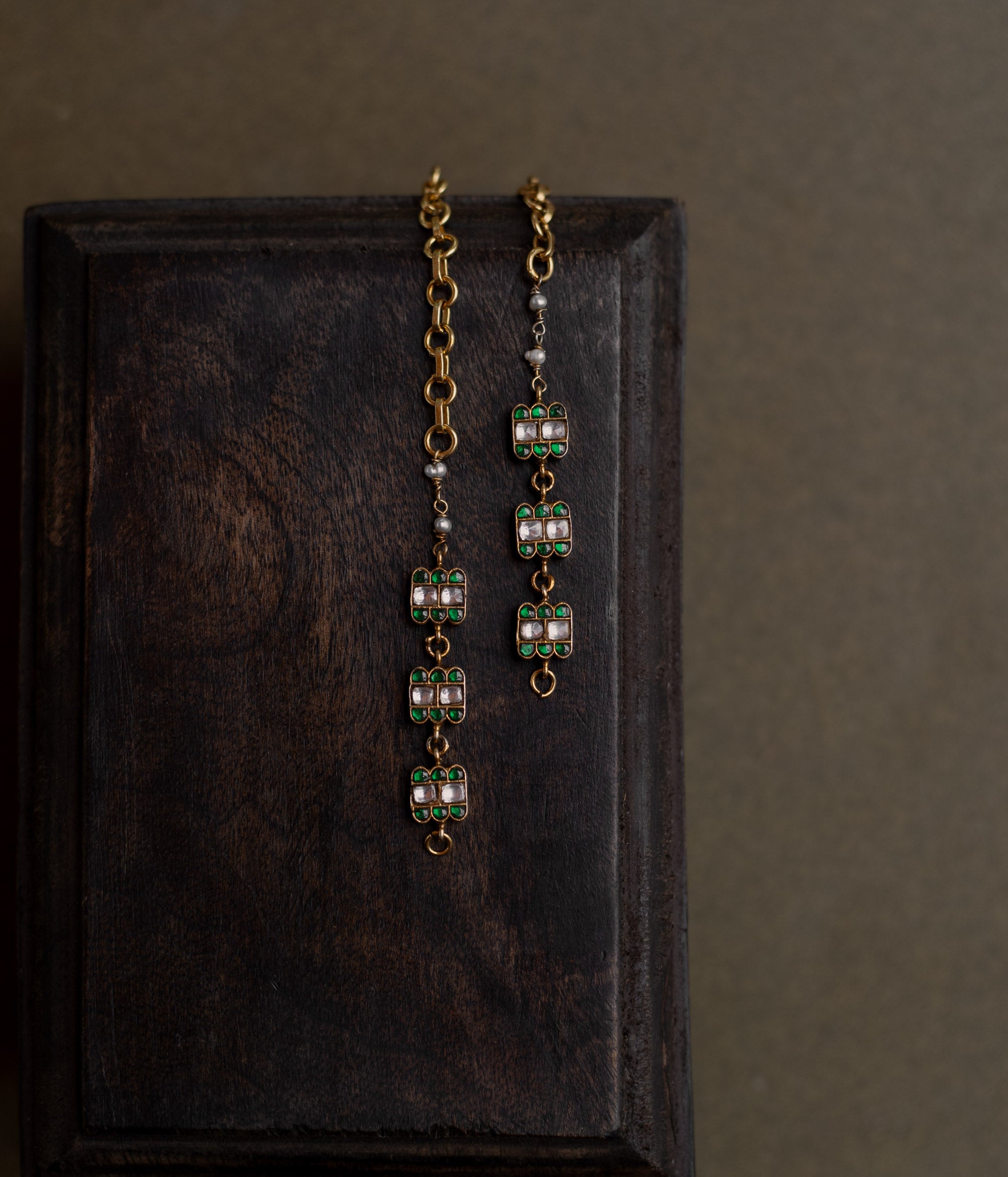 Kundan Collection ear chain with green kundan petals and white kundan stones in blooming vine design.