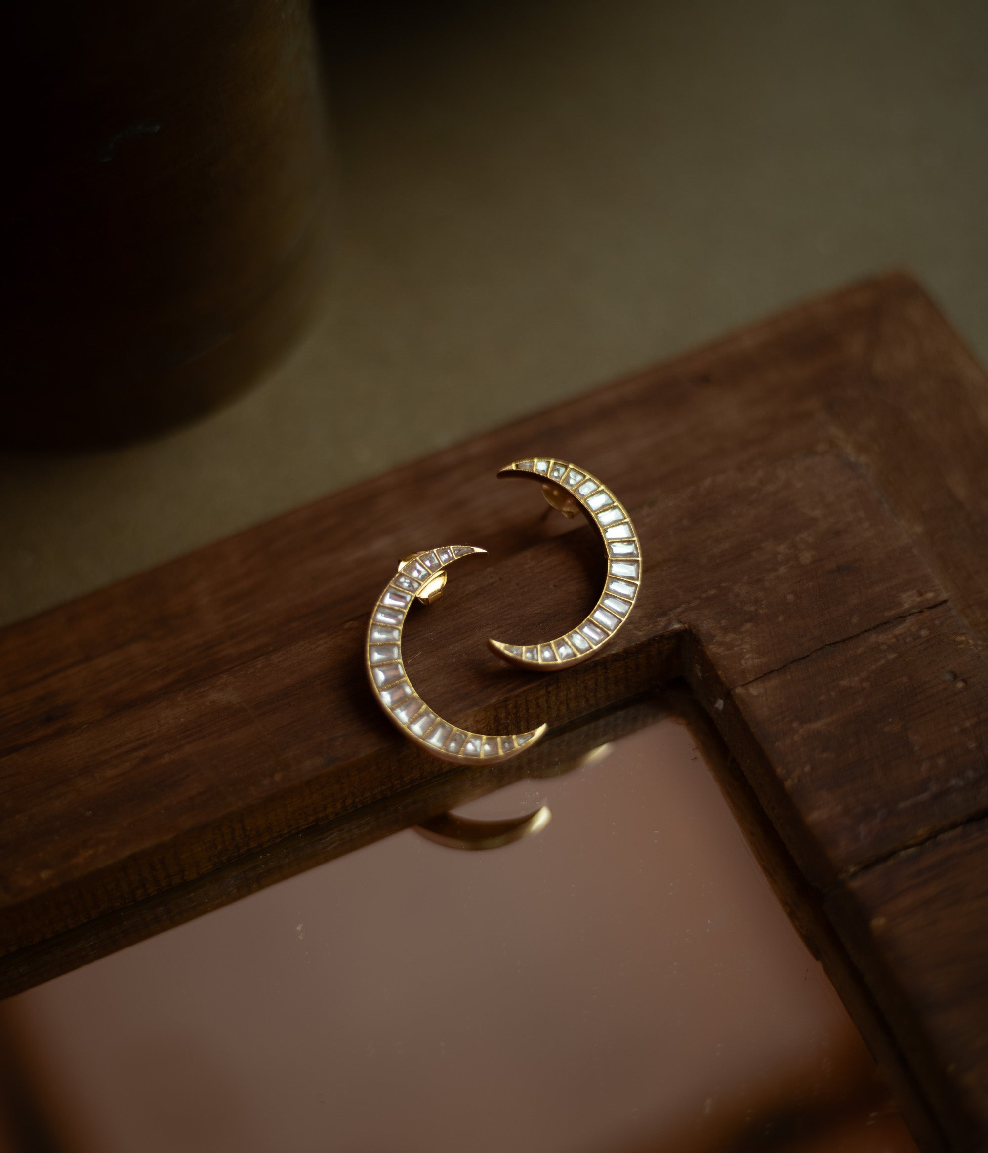 Crescent-shaped Kundan earrings with white stones set in gold, inspired by moonlit elegance.