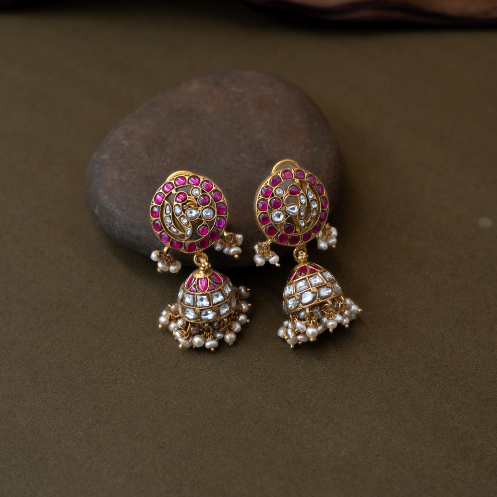 Vibrant Rang Mahal Jadau Earrings blending classic meenakari artistry with Kundan sparkle. Circular studs with ruby pink and mirror-polished white stones flow into dome-shaped jhumkas finished with delicate pearl hangings, perfect for weddings and festive occasions.