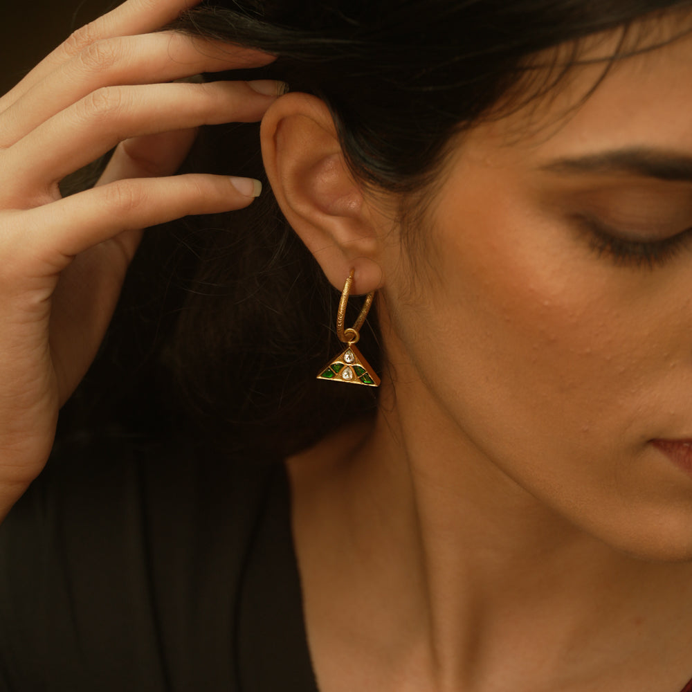 Triangular kundan earrings with reversible green and red kundan stones, accented by a central white kundan.