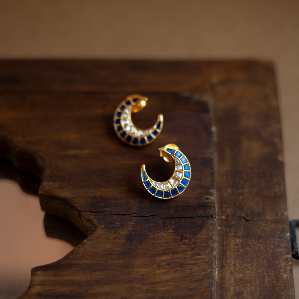 Teardrop earrings with a floral pattern of blue and white Kundan stones and a hanging pearl.