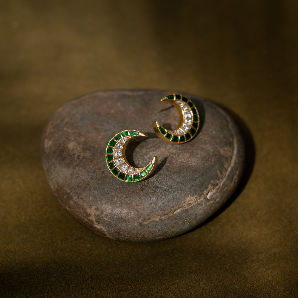 Floral earrings with a green Kundan center and white Kundan petals.