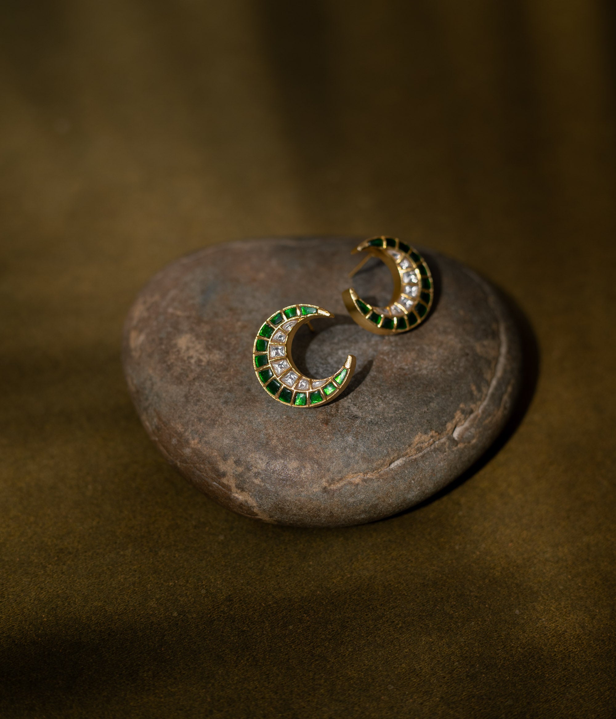 Floral earrings with a green Kundan center and white Kundan petals.