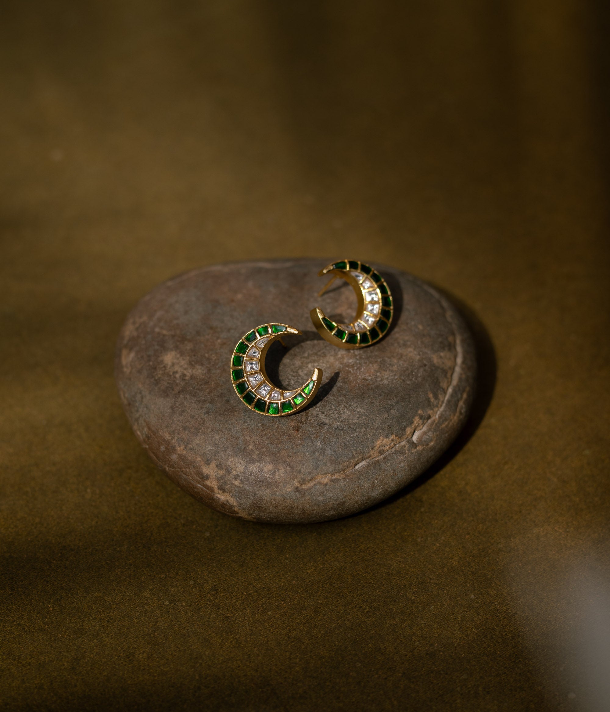 Floral earrings with a green Kundan center and white Kundan petals.