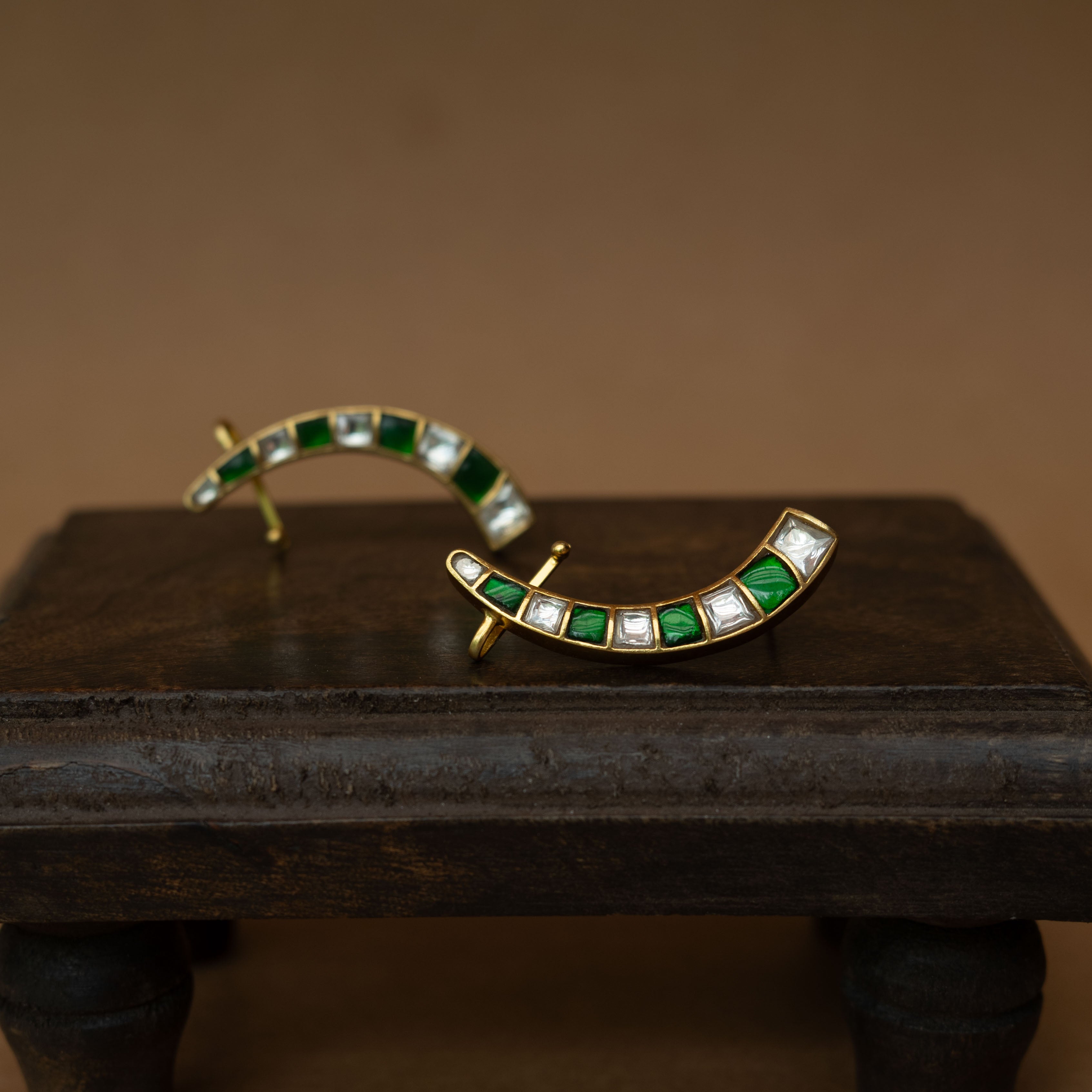Curved ear crawlers with alternating green and white square stones.