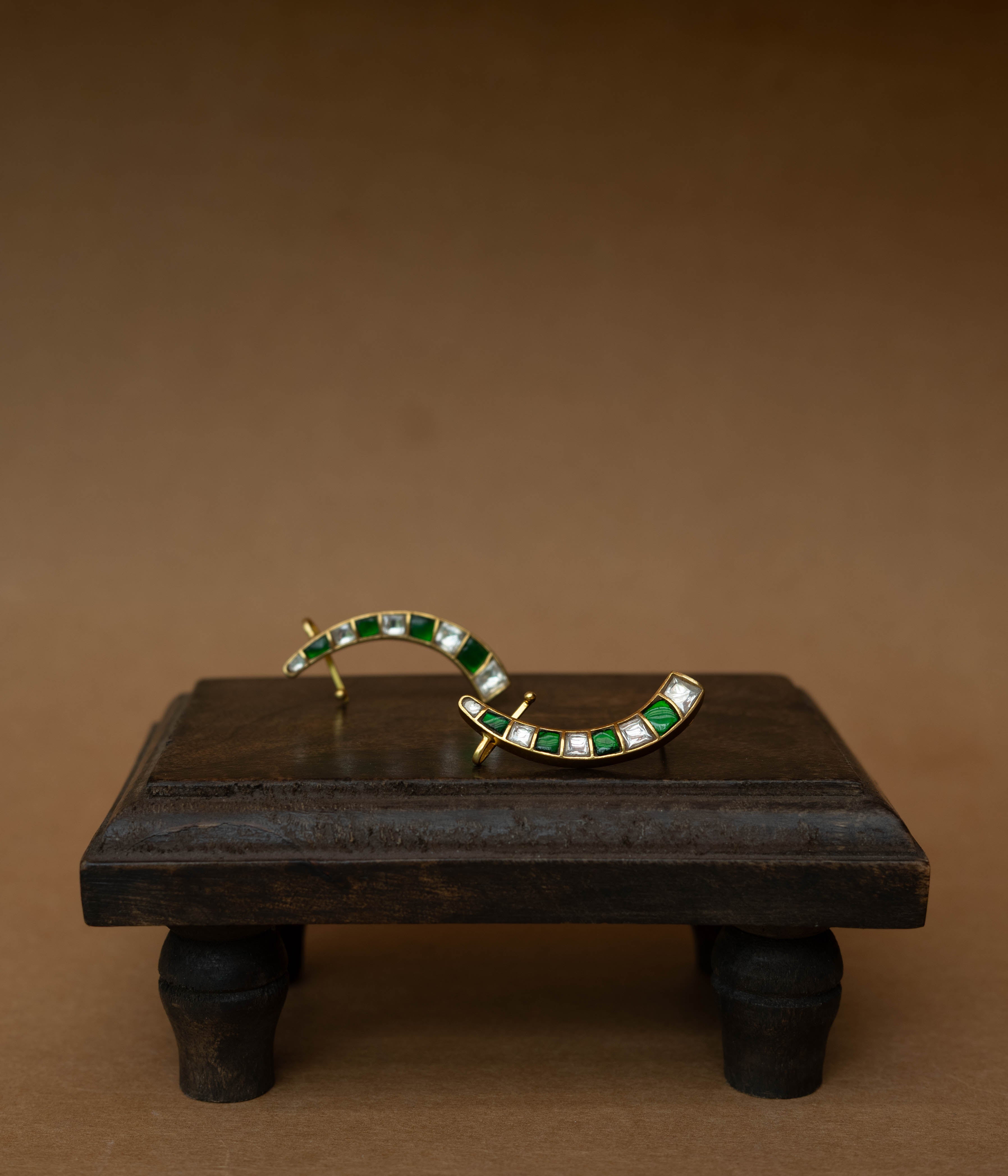 Curved ear crawlers with alternating green and white square stones.