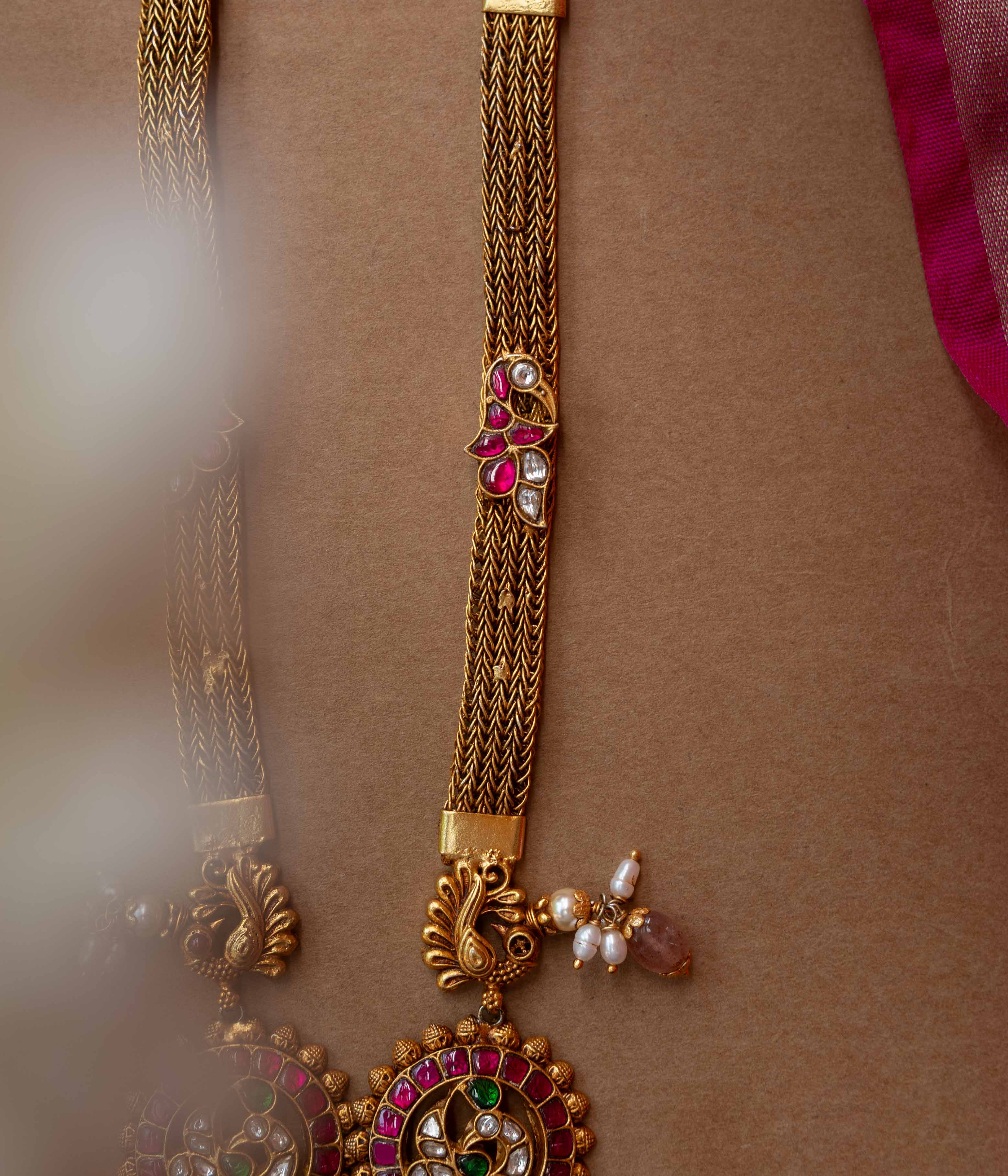 A multi-layered Kundan necklace with a central pendant and cascading strands of pearls and beads.